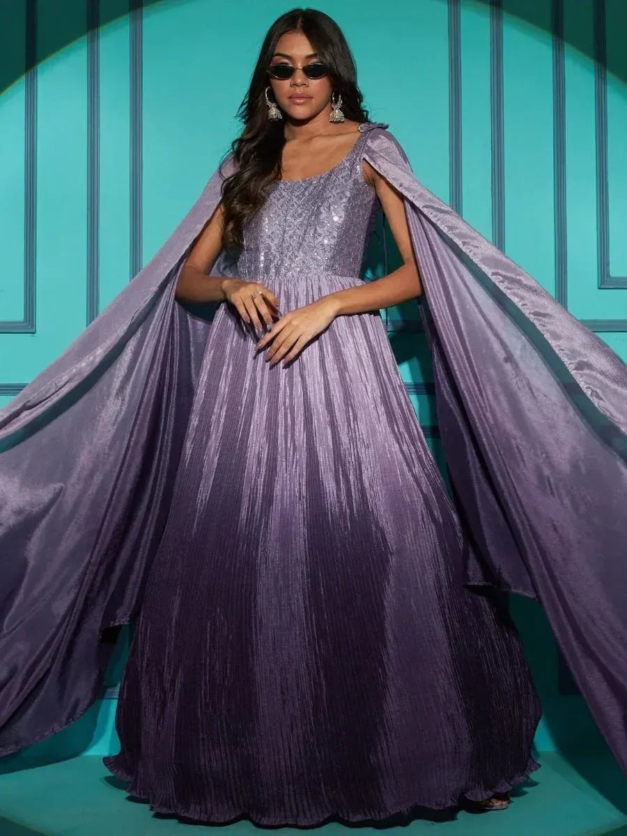 Woman wearing a lavender ethnic gown with sequin bodice and dramatic cape sleeves