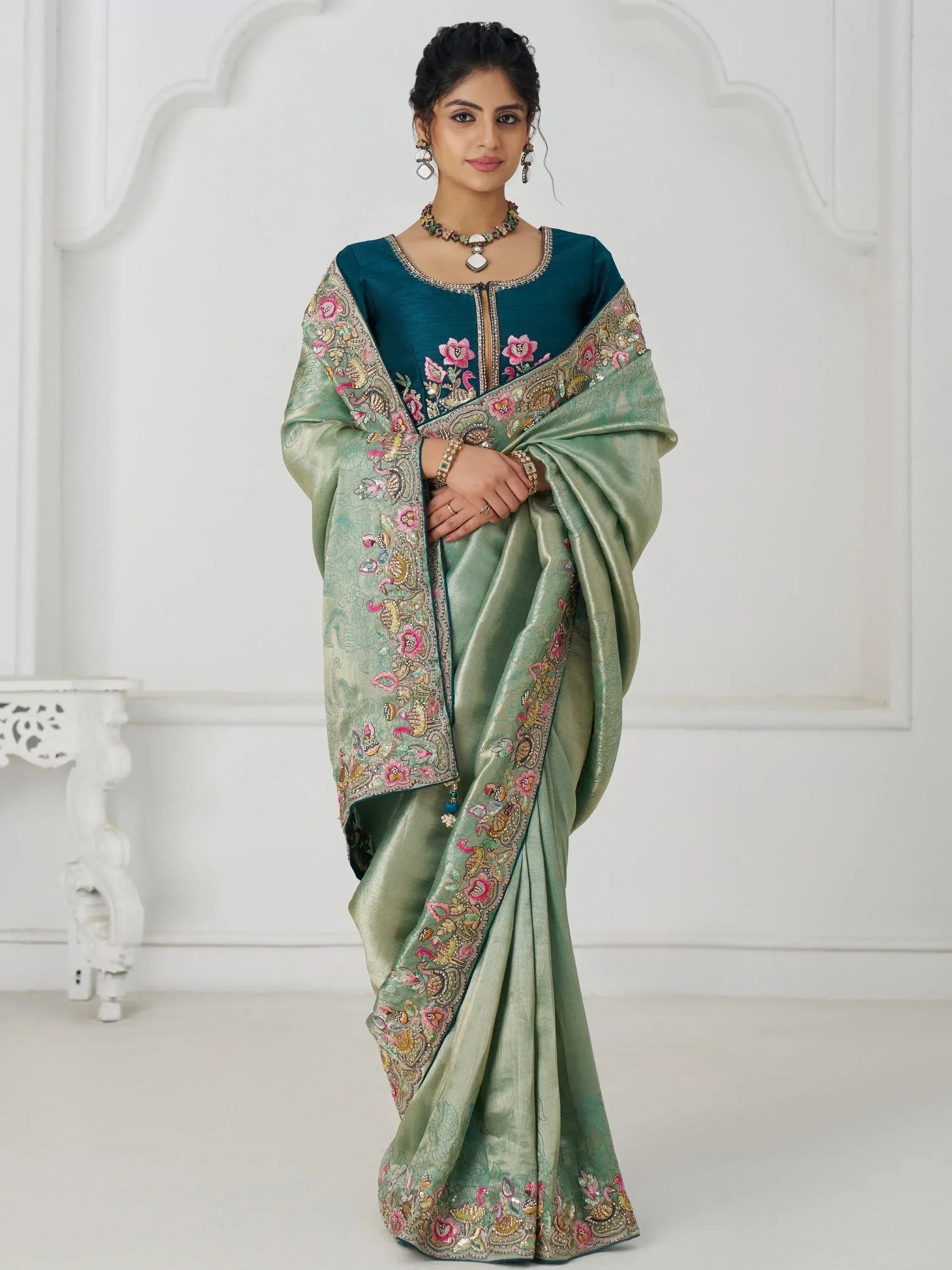 Elegant green saree with floral embroidery and teal blouse, perfect for Indian ethnic occasions