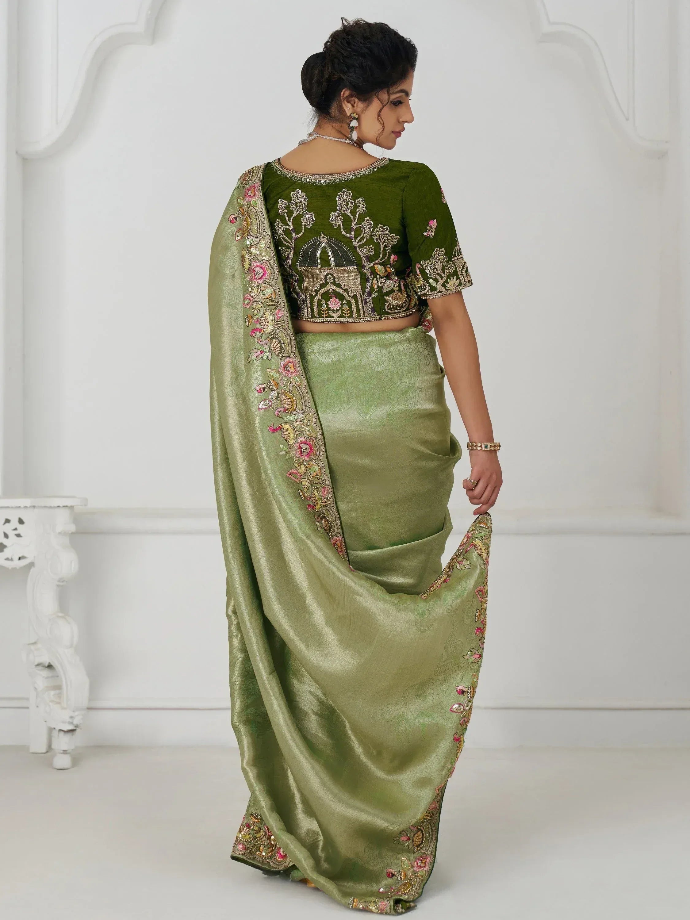 Olive green designer saree with intricate floral and architectural embroidery, perfect for ethnic occasions.