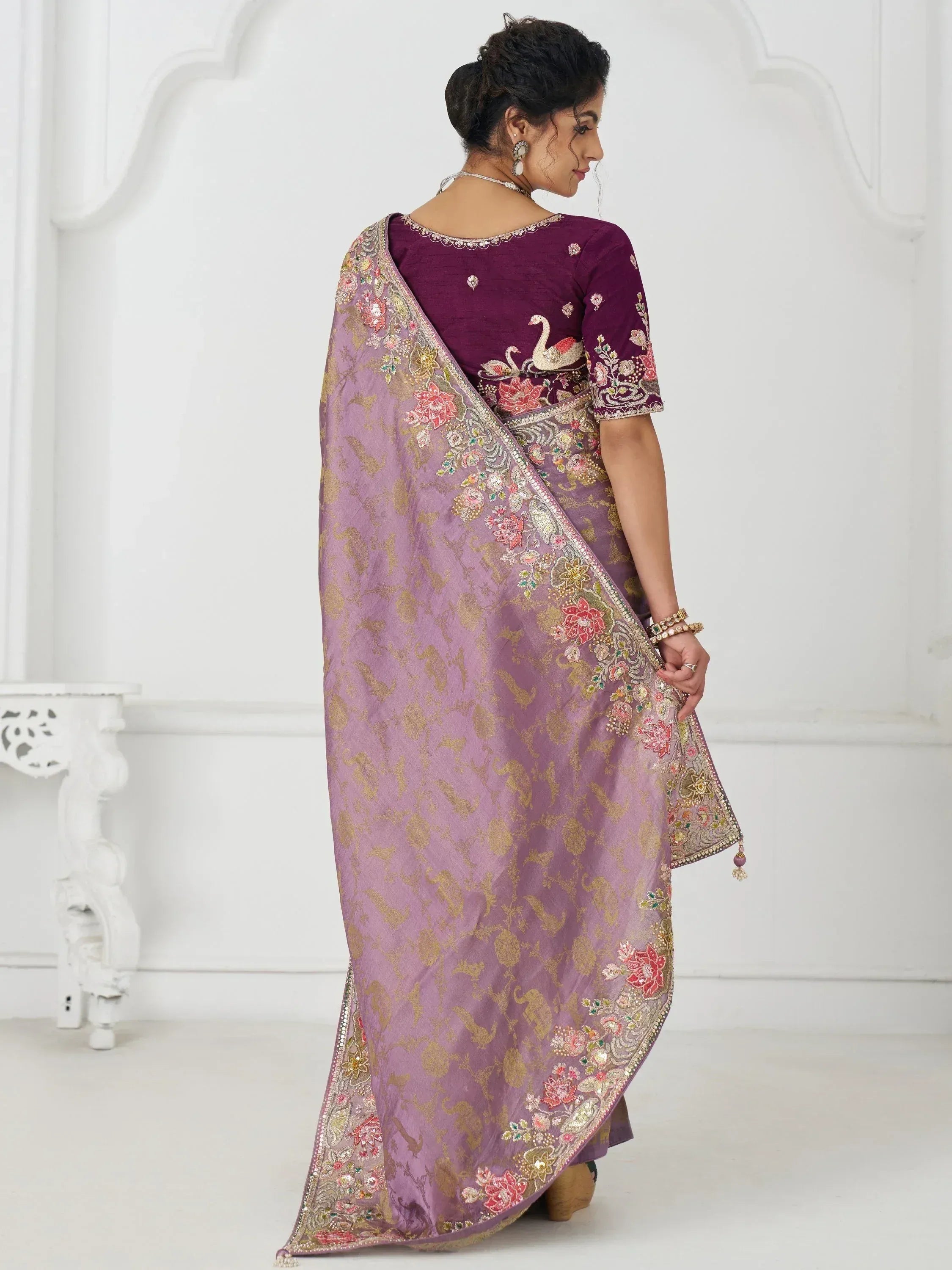 Purple embroidered saree with floral and swan motifs, paired with matching blouse for Indian ethnic wear