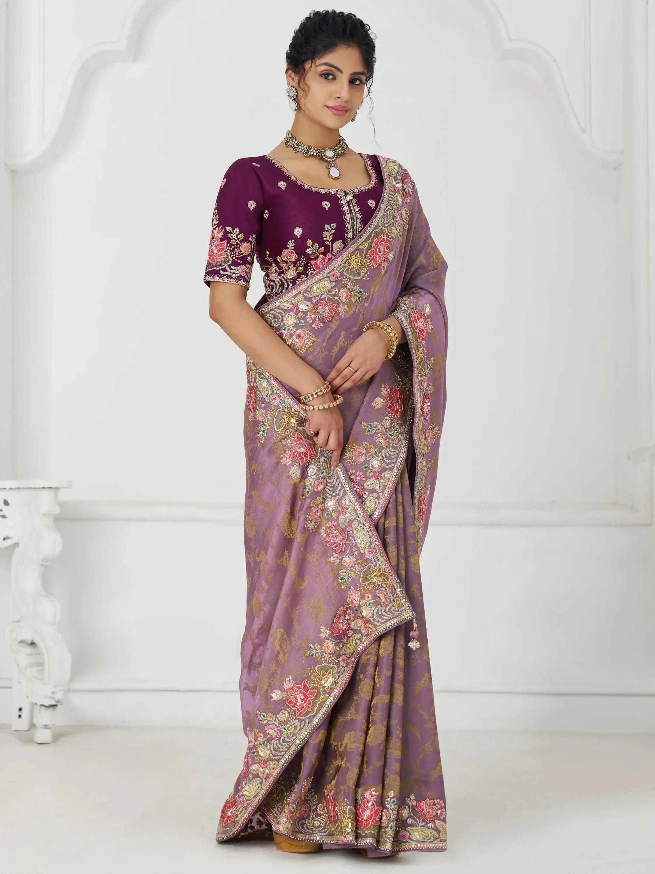 Elegant purple saree with floral embroidery and gold detailing, paired with matching blouse for festive occasions