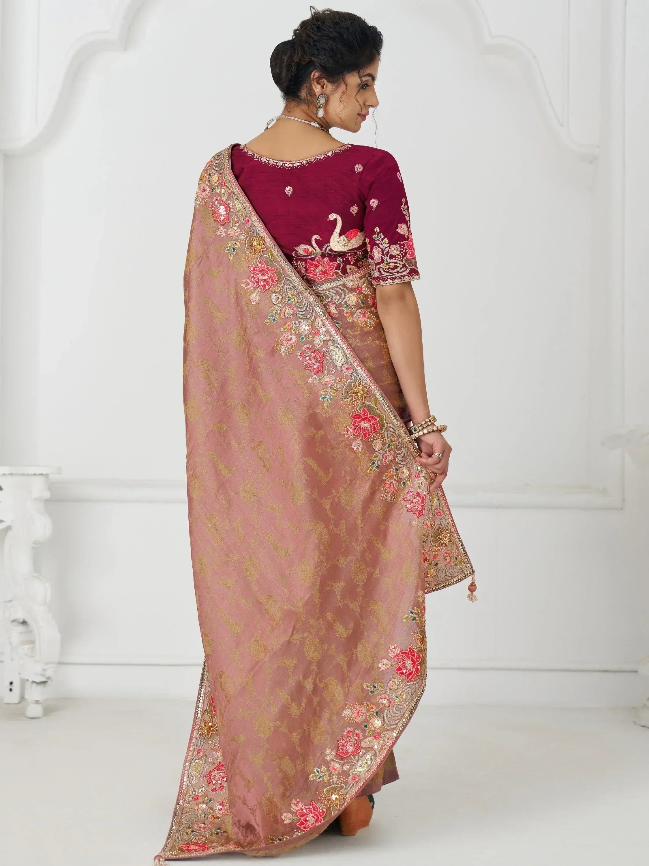Elegant maroon and pink embroidered saree with floral and swan motifs, perfect for Indian ethnic occasions.