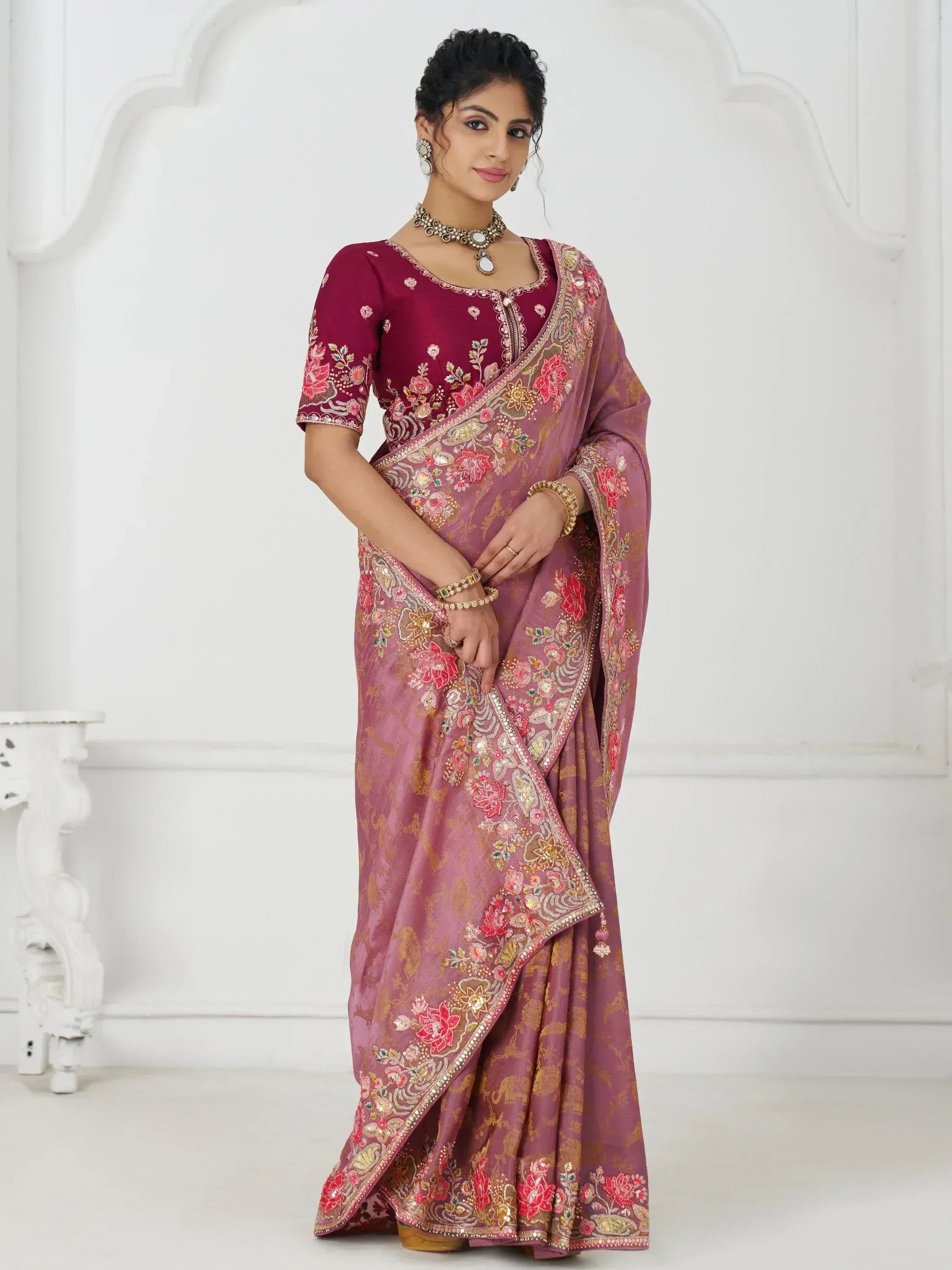 Woman in elegant maroon and mauve embroidered saree with floral motifs, perfect for Indian ethnic occasions
