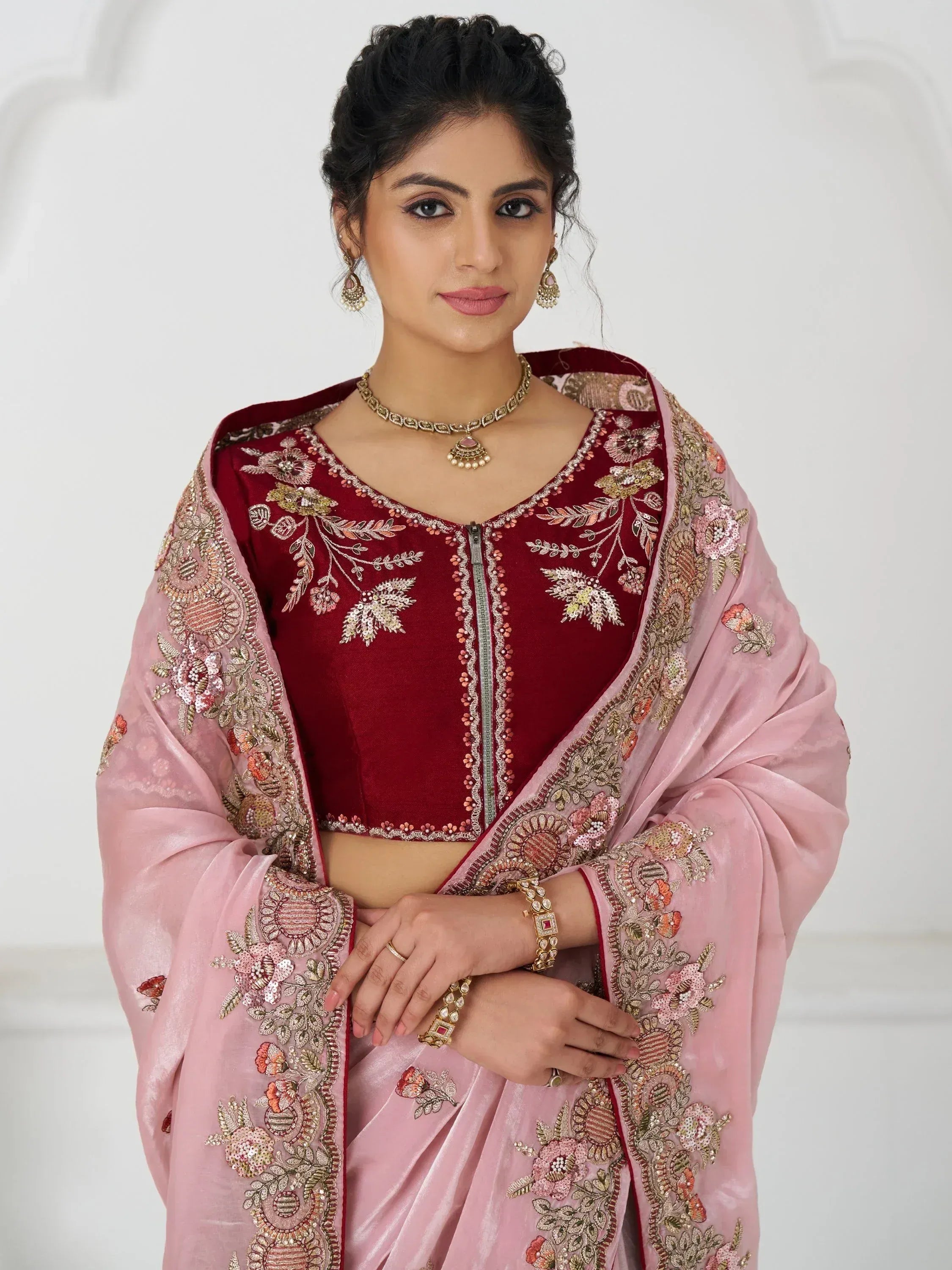 Elegant maroon velvet crop top with floral embroidery paired with pink saree, perfect for Indian ethnic wear occasions.