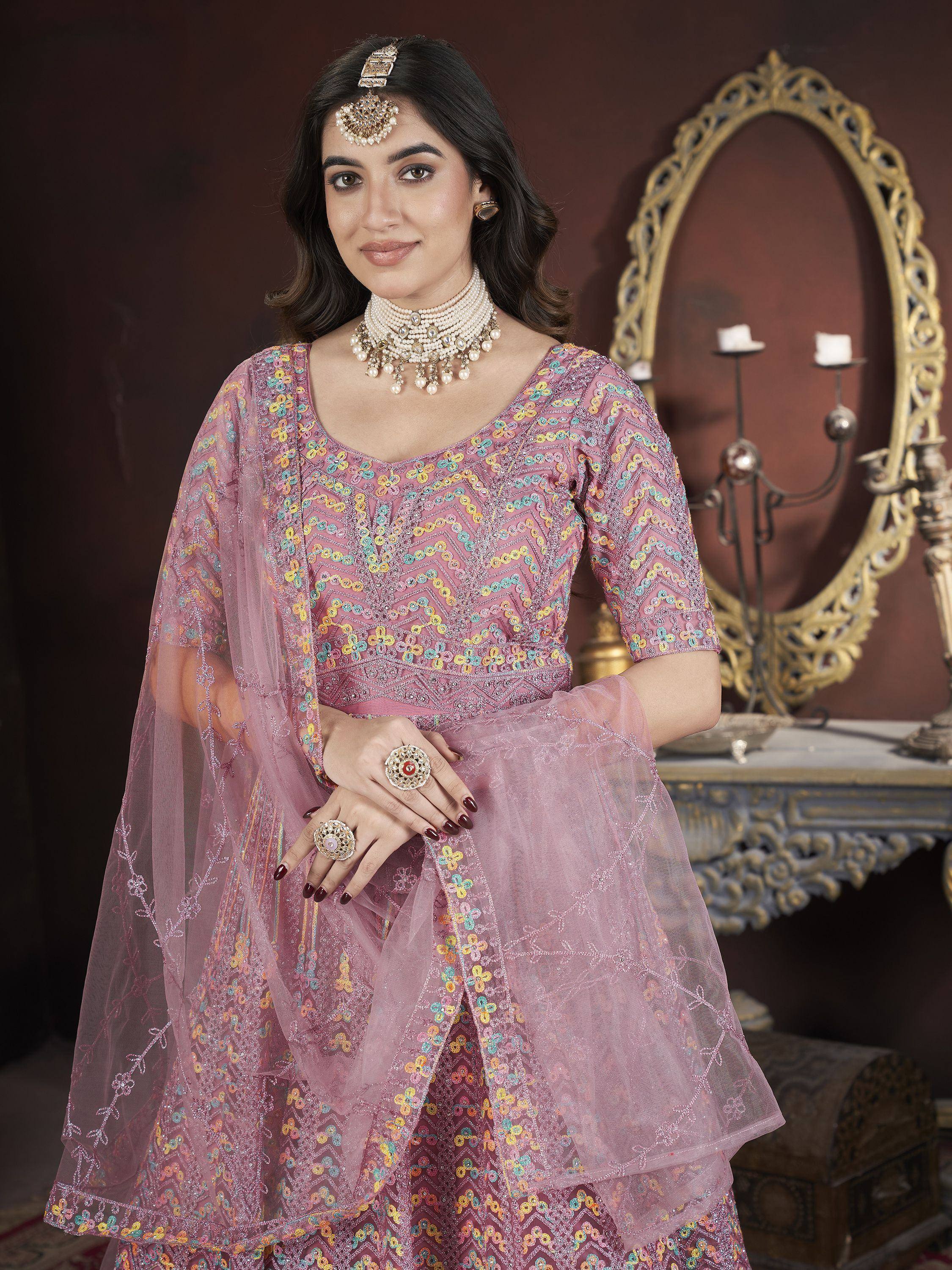 Elegant pink embroidered lehenga choli with floral patterns and traditional jewelry