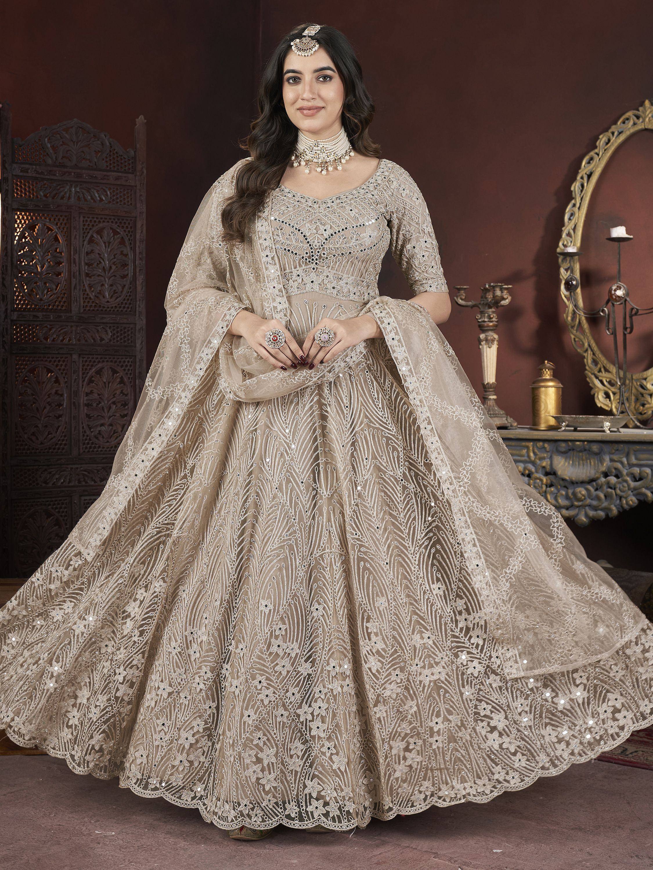 Elegant beige designer lehenga choli with intricate embroidery and sequins, perfect for Indian weddings and festive occasions.