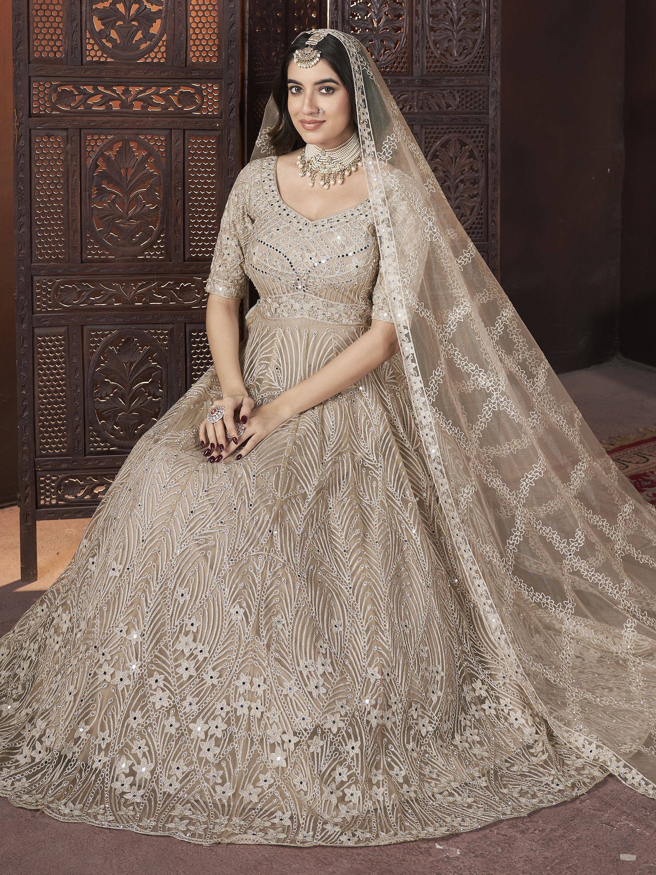 Elegant beige lehenga choli with intricate embroidery and sequin work, paired with a matching dupatta, perfect for Indian weddings and festive occasions.