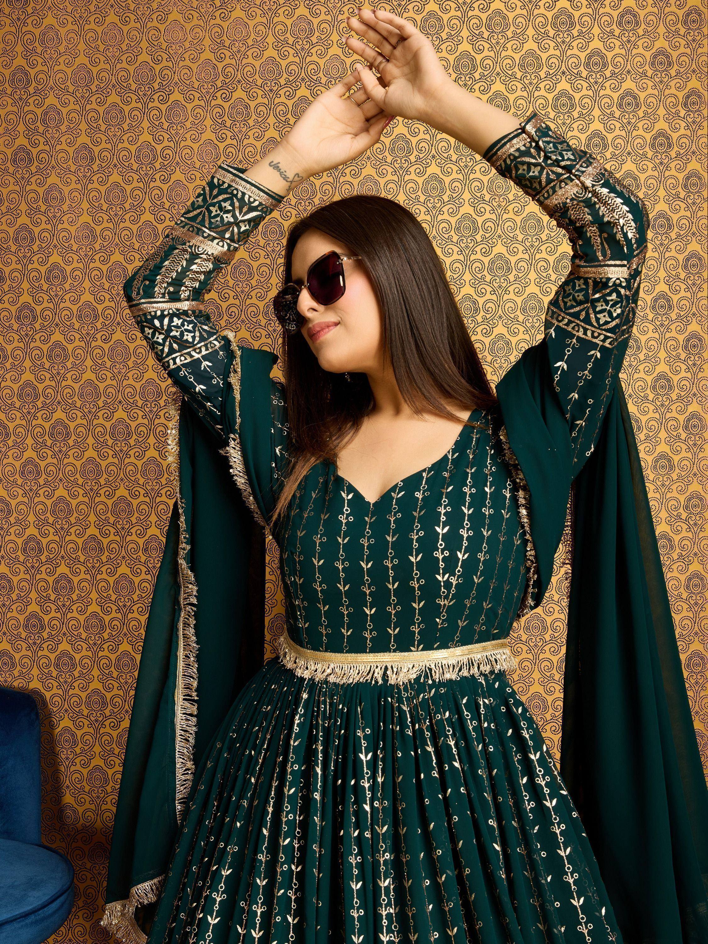 Emerald green ethnic gown with gold embroidery, perfect for Indian occasions and festive wear.
