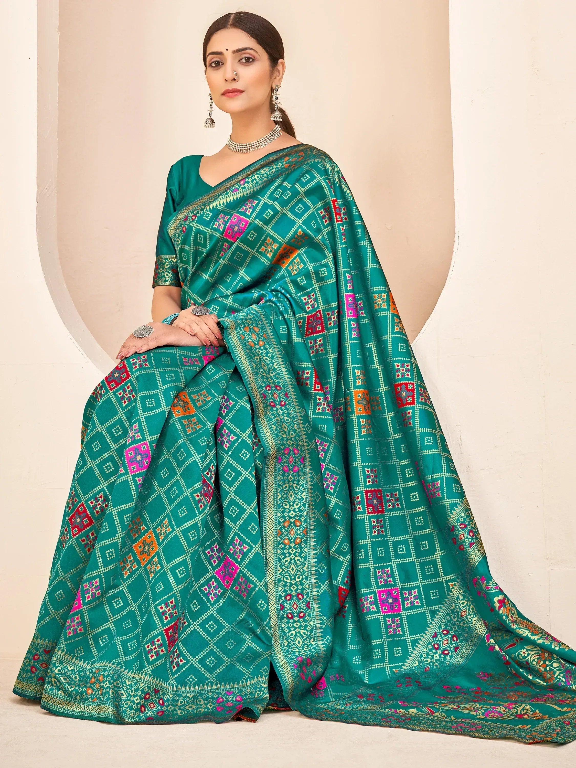 Teal green ethnic saree with colorful geometric embroidery, perfect for Indian occasions and festivals.