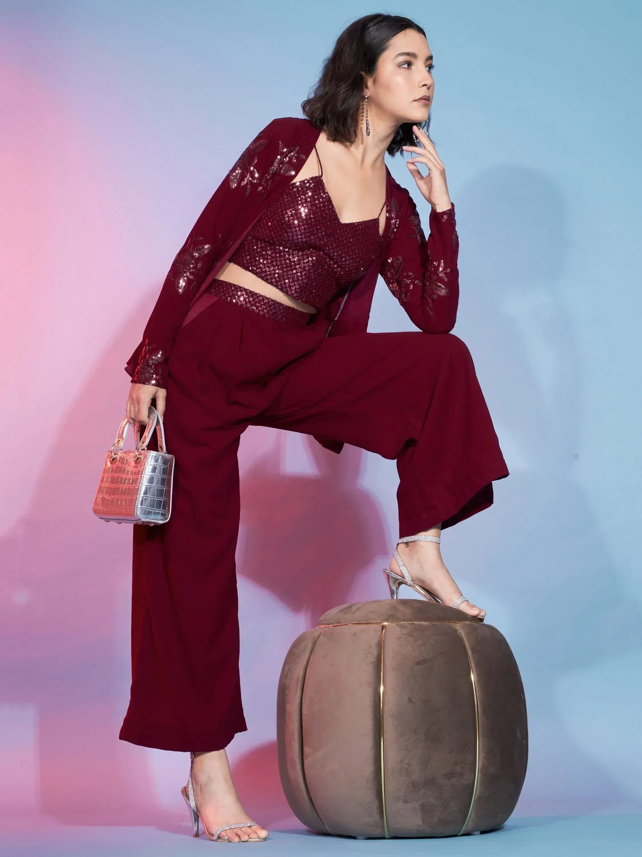 Maroon sequin crop top with matching pants and jacket, styled with heels and a handbag
