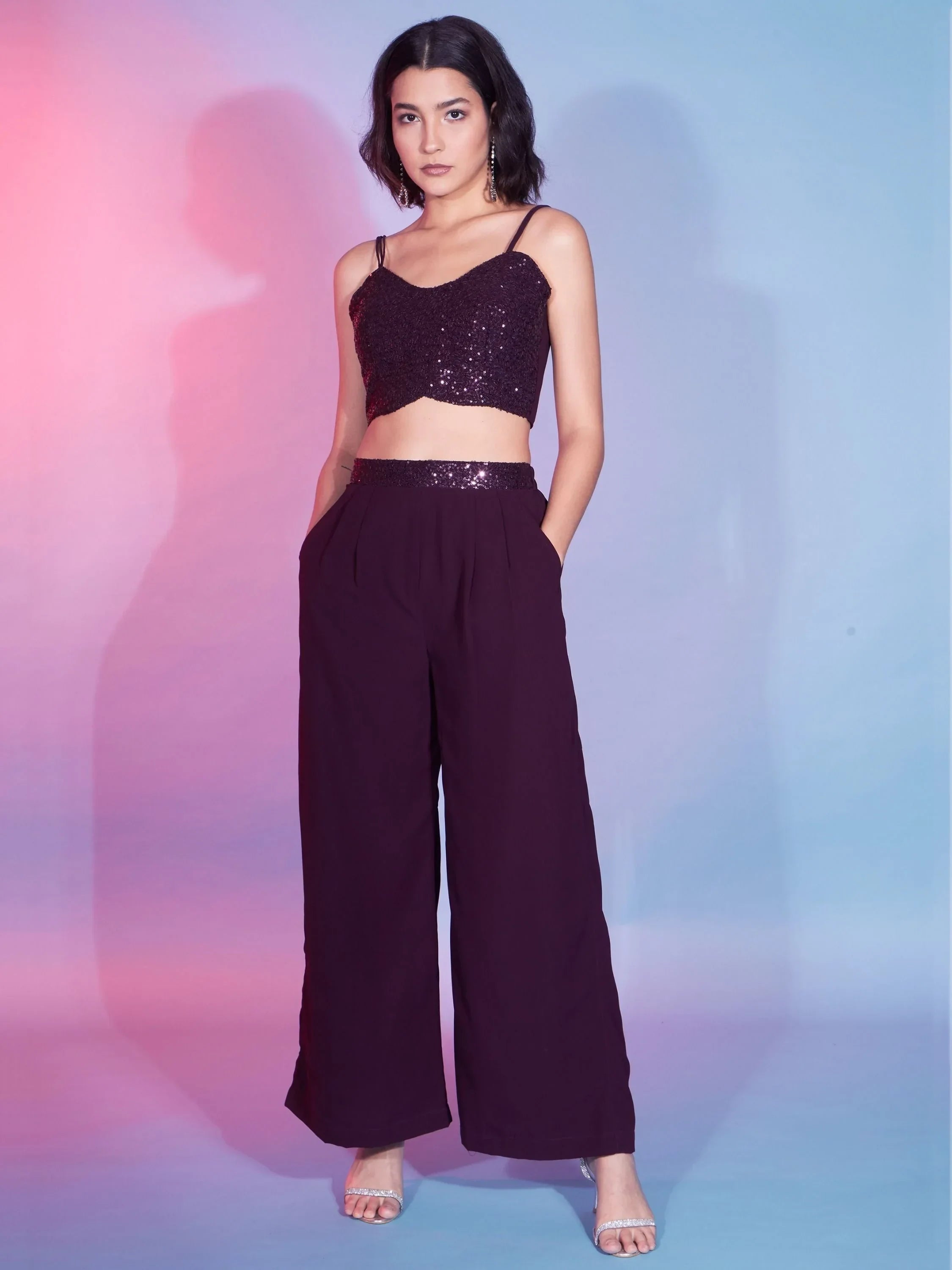 Woman wearing a dark purple sequin crop top and wide-leg pants, fashion outfit