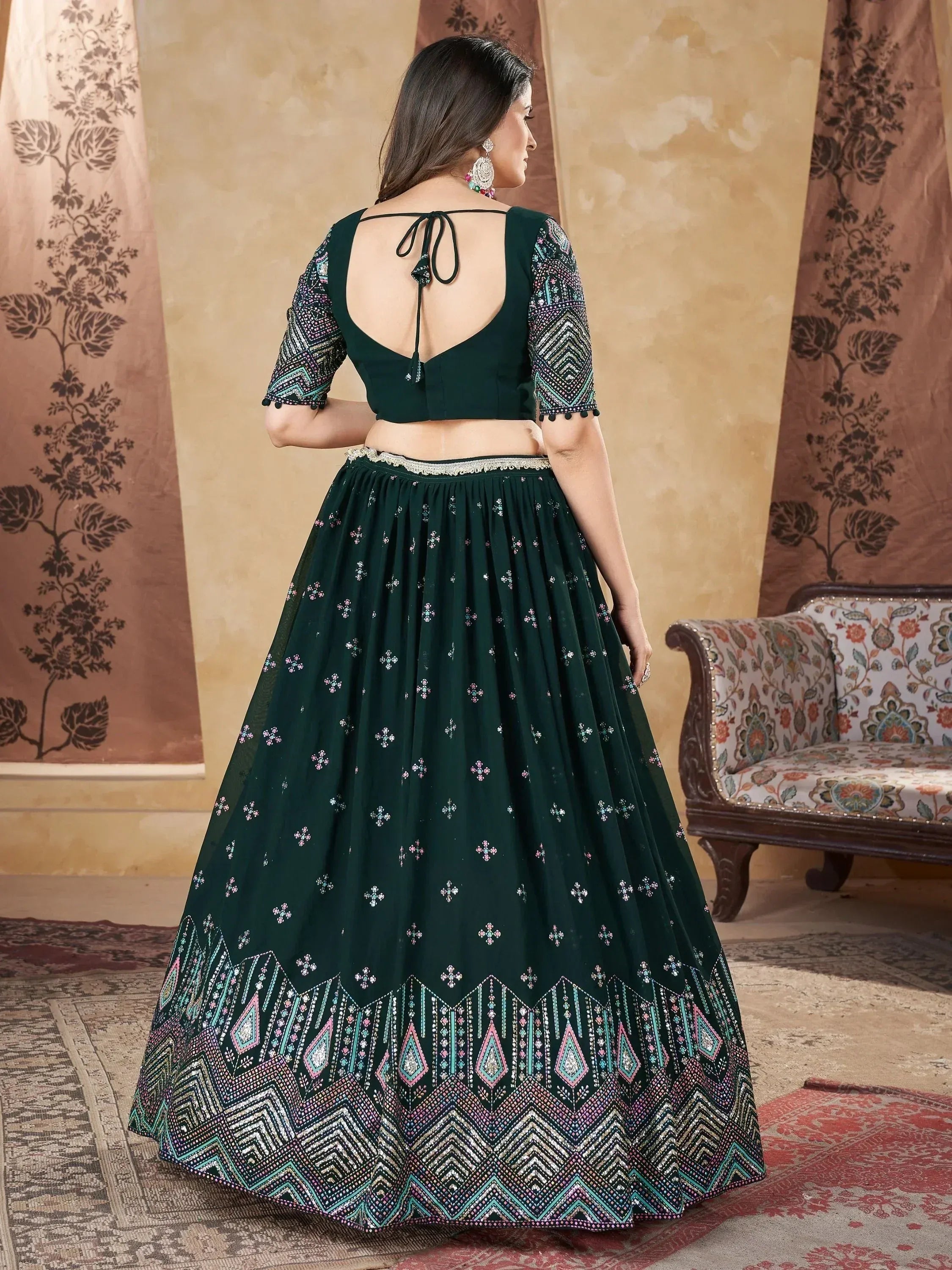 Emerald green designer lehenga choli with intricate embroidery and back tie blouse, perfect for Indian ethnic wear.