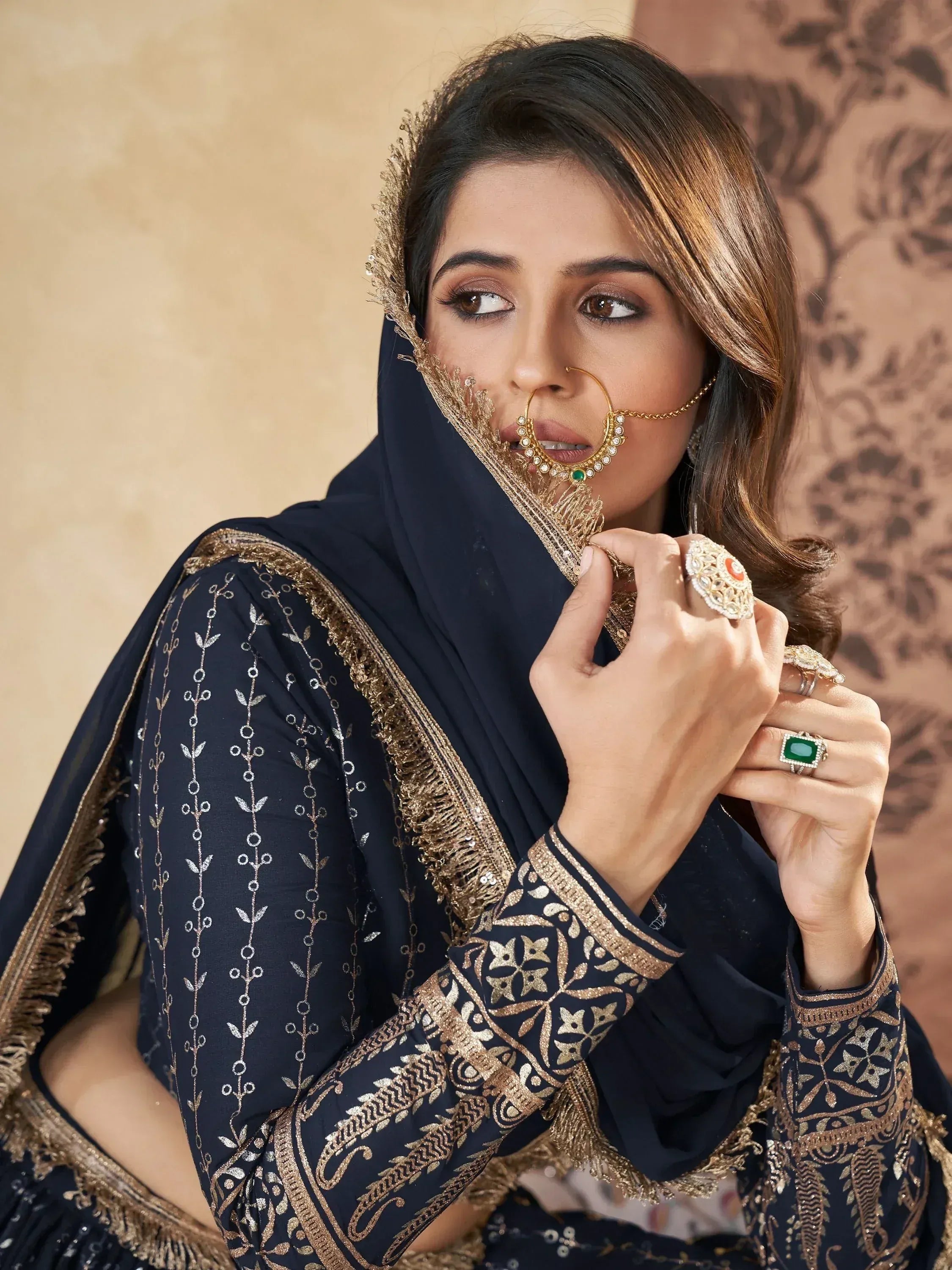 Elegant navy blue salwar kameez with gold embroidery, paired with traditional Indian jewelry and nose ring.