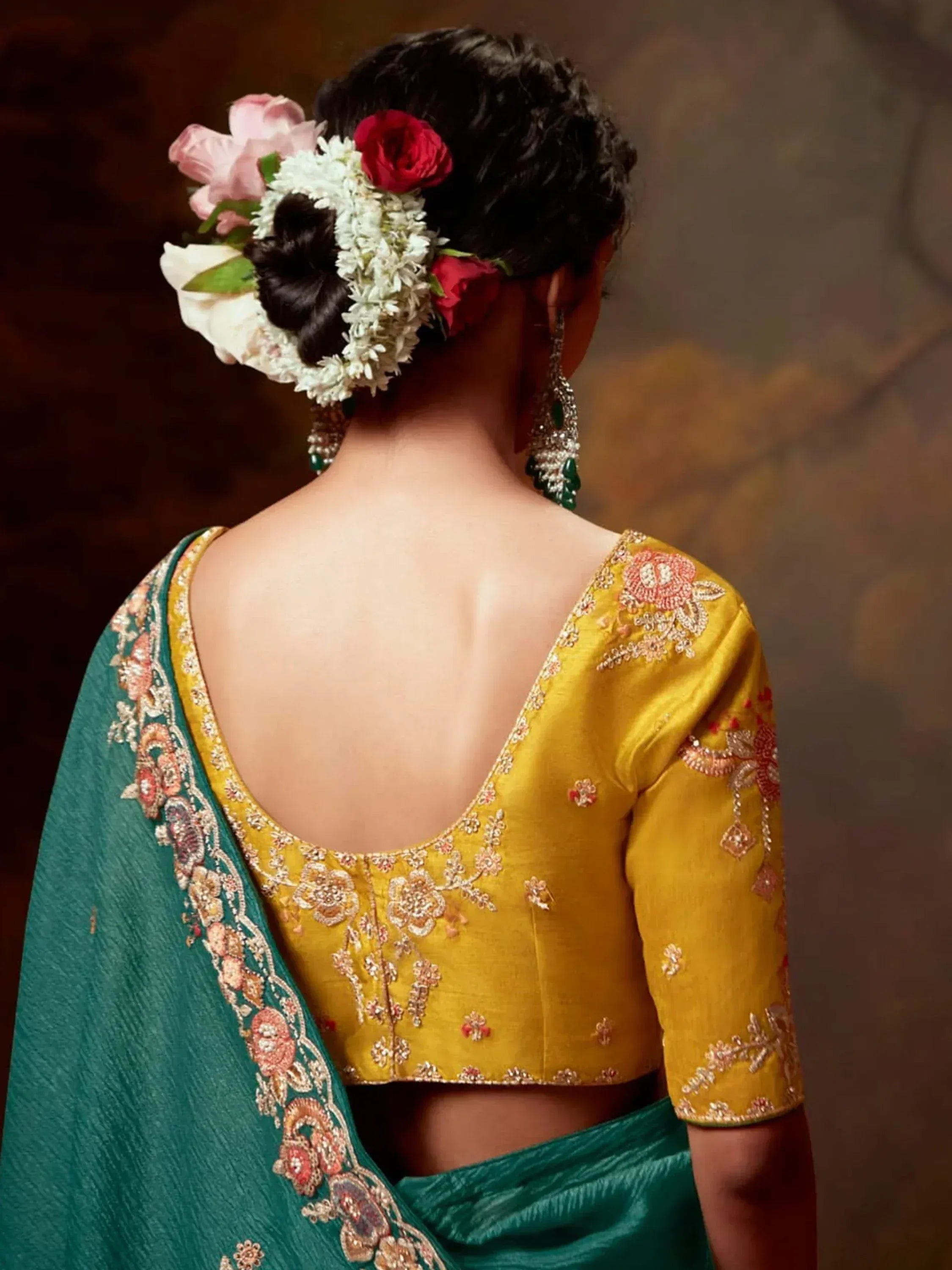 Yellow embroidered blouse with green saree, floral hair accessory, and statement earrings for Indian ethnic wear