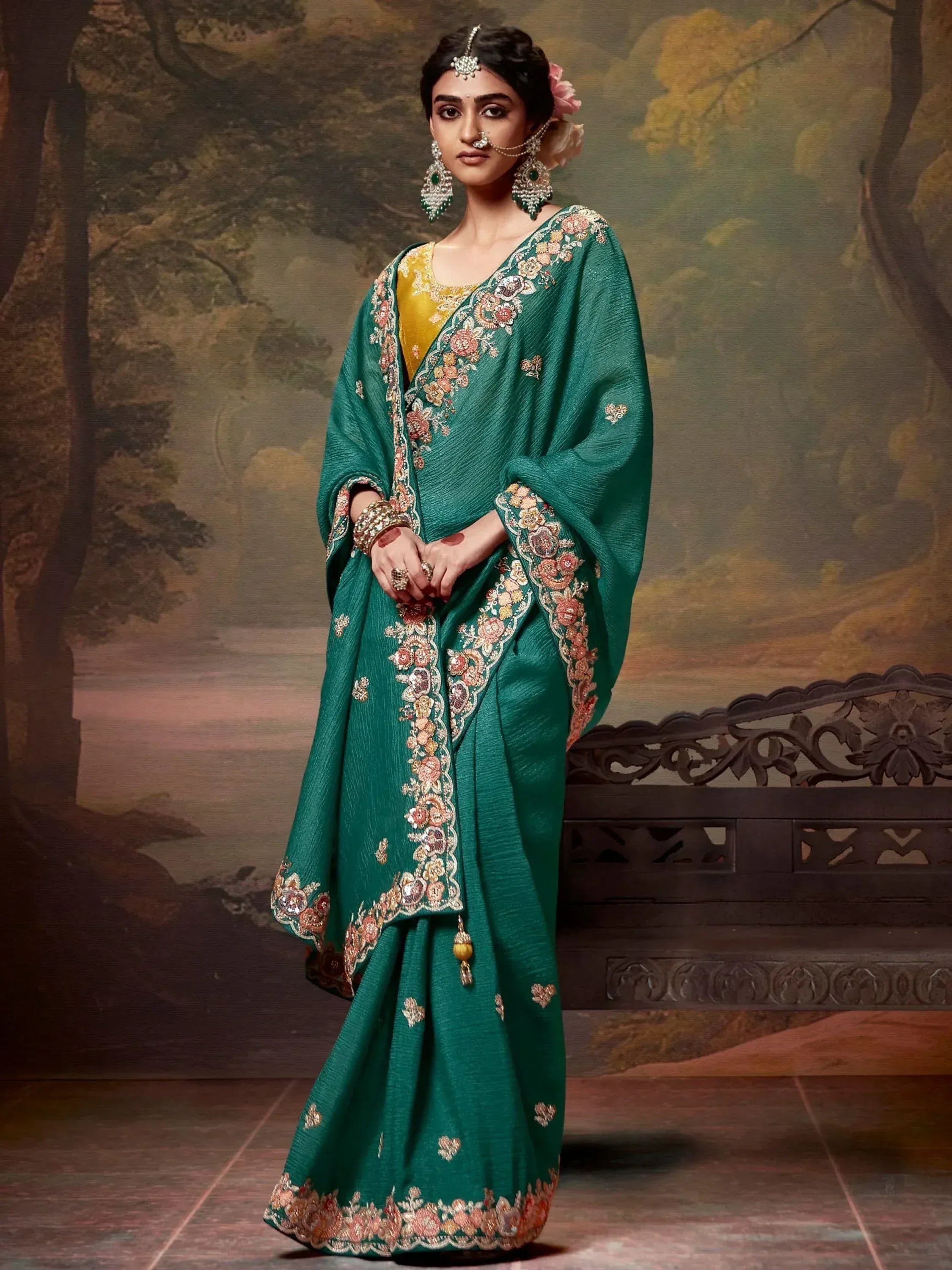 Emerald green embroidered saree with gold blouse, floral detailing, and traditional Indian jewelry for festive occasions