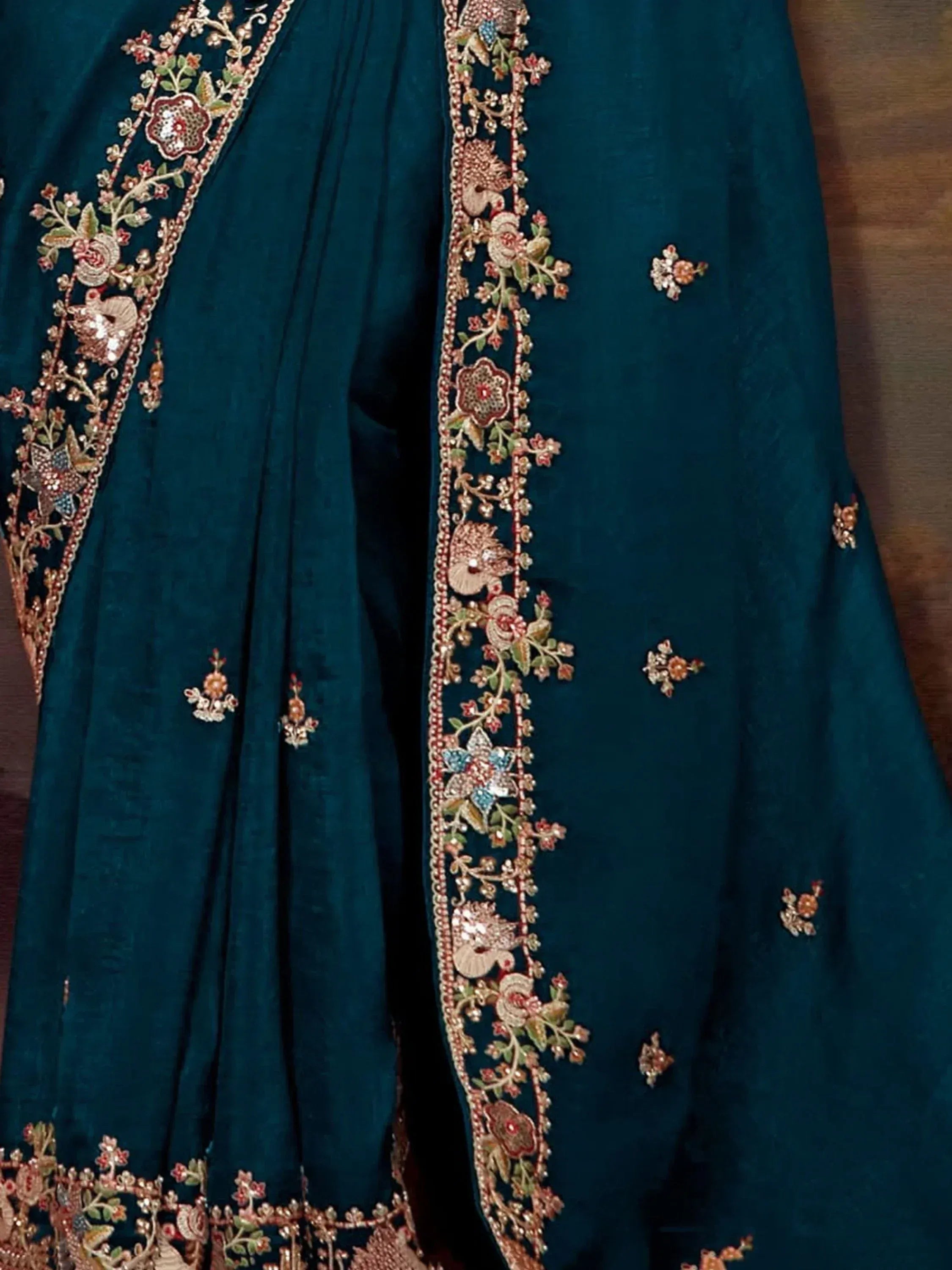 Teal velvet lehenga with intricate floral and peacock embroidery, perfect for Indian ethnic wear.
