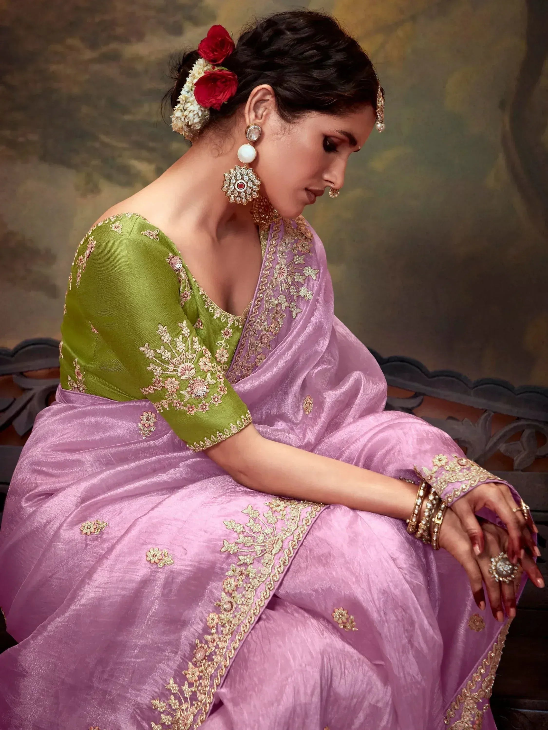 Woman in lavender saree with green blouse, floral embroidery, and traditional jewelry