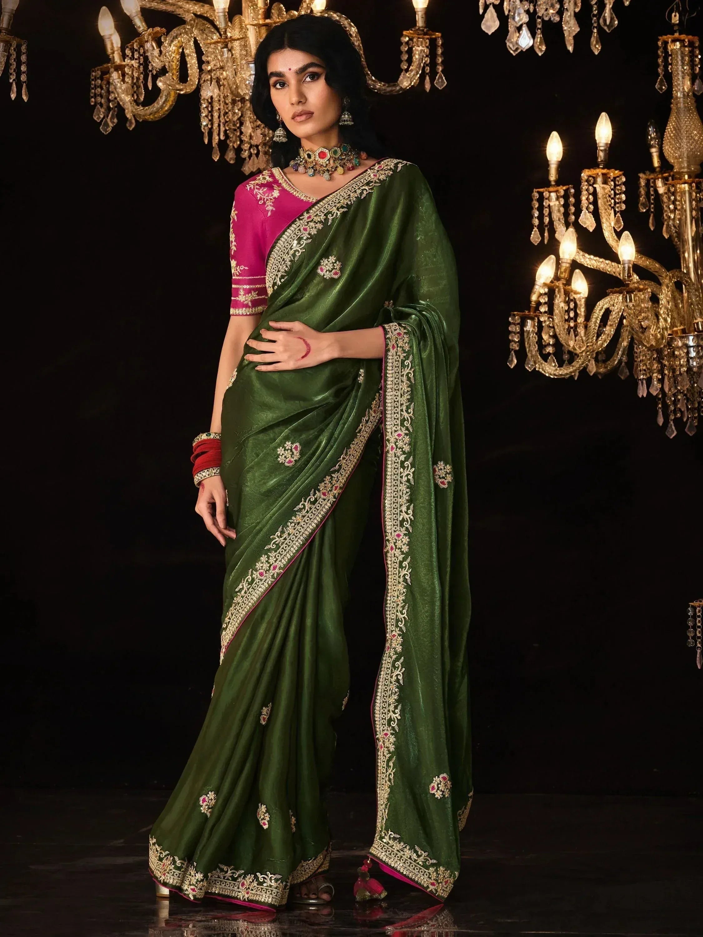 Elegant green velvet saree with gold embroidery and pink blouse, perfect for Indian ethnic wear occasions.