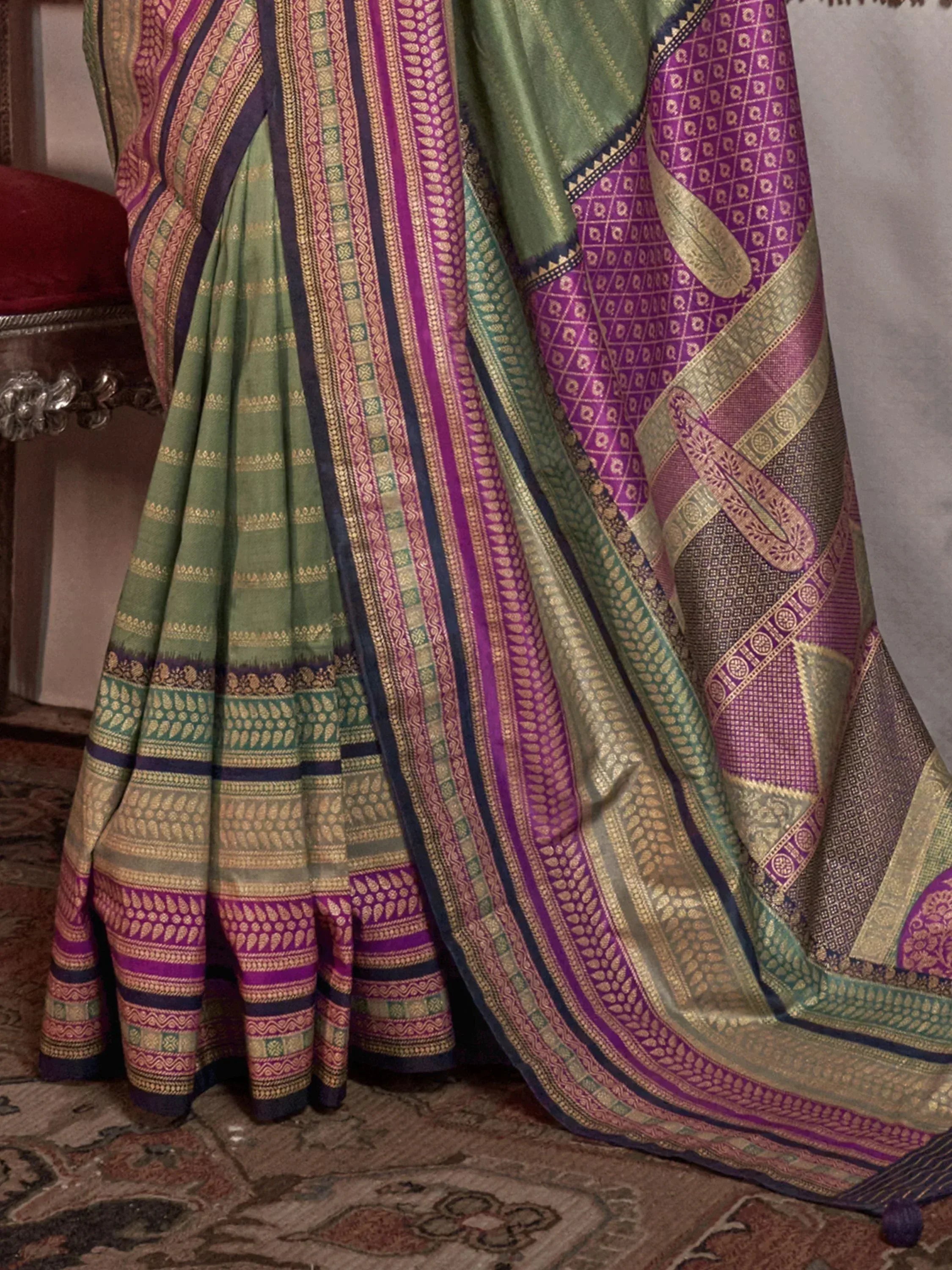 Green and purple designer saree with intricate gold patterns and border details