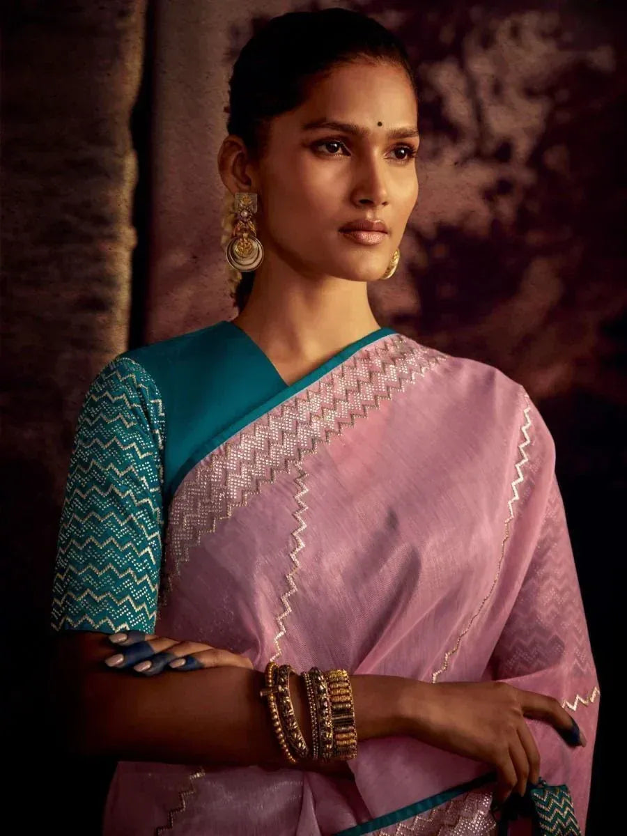 Pink and teal designer saree with zigzag embroidery, paired with statement gold jewelry for ethnic wear