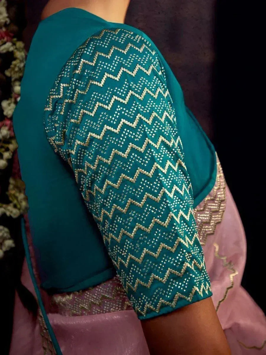 Teal ethnic blouse with gold zigzag embroidery and stone work, paired with pink lehenga