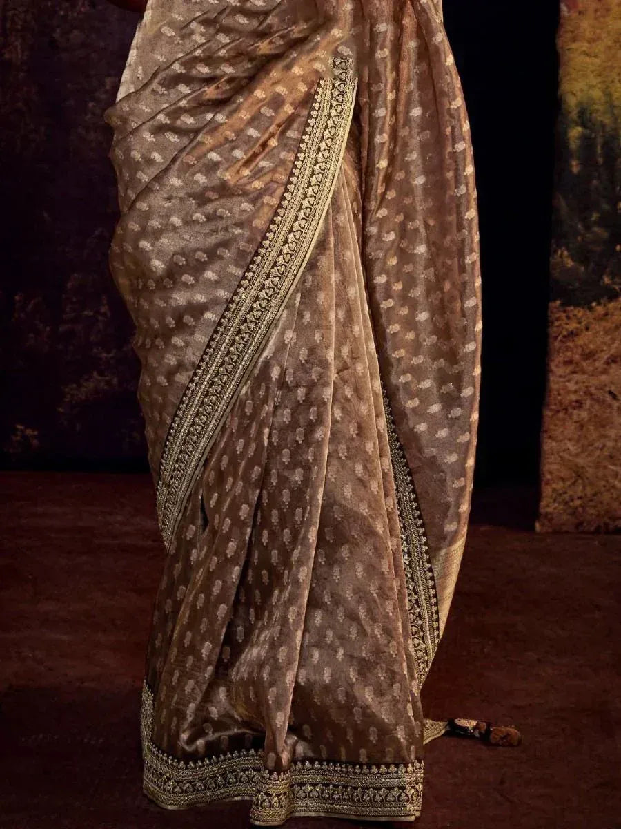 Brown designer saree with gold floral print and intricate border, ideal for ethnic occasions