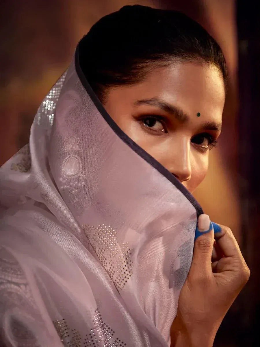 Elegant woman in sheer lavender dupatta with sequin embroidery, showcasing traditional Indian ethnic wear.