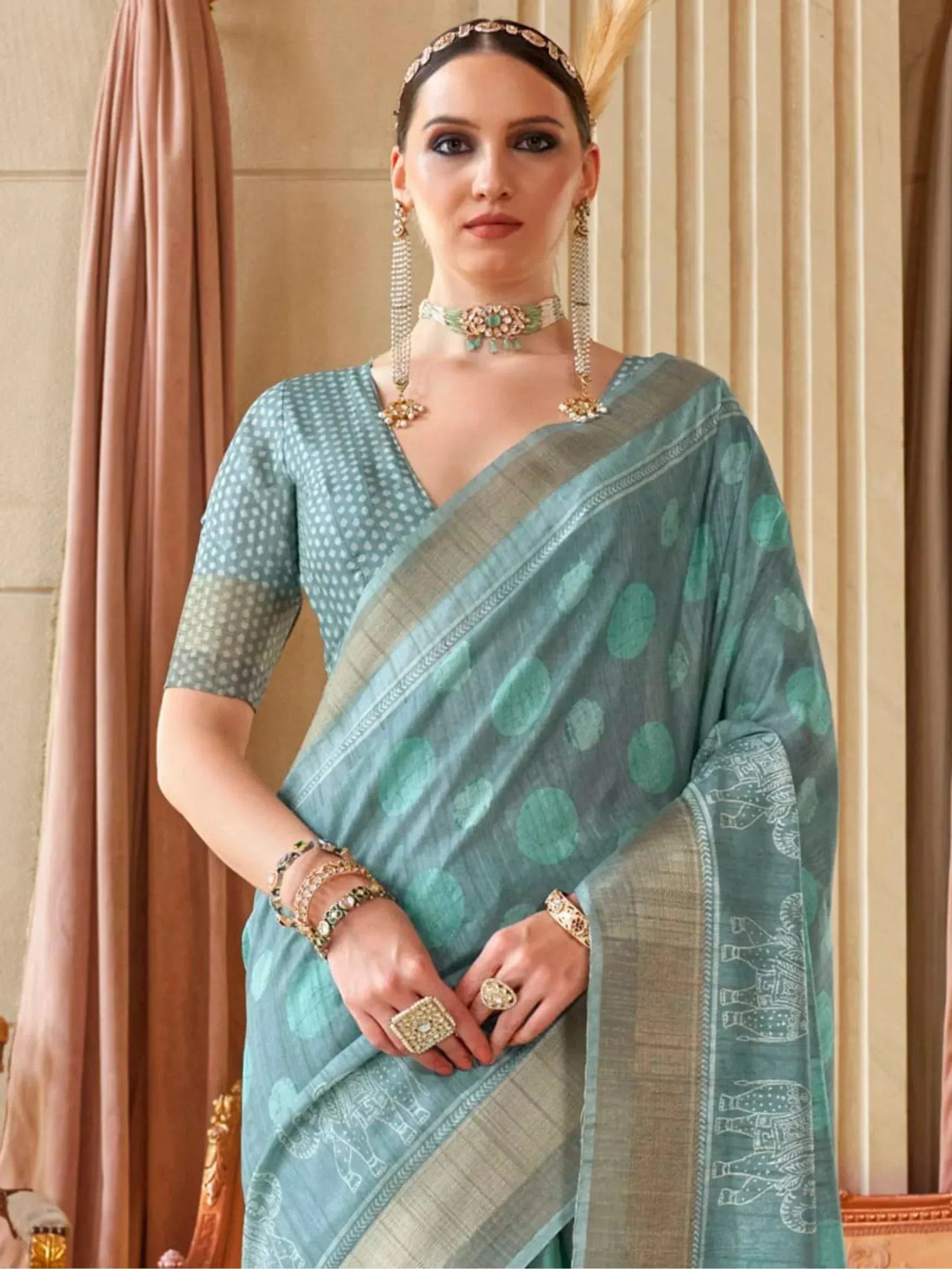 Elegant teal saree with polka dots and elephant print, paired with traditional jewelry for Indian ethnic wear