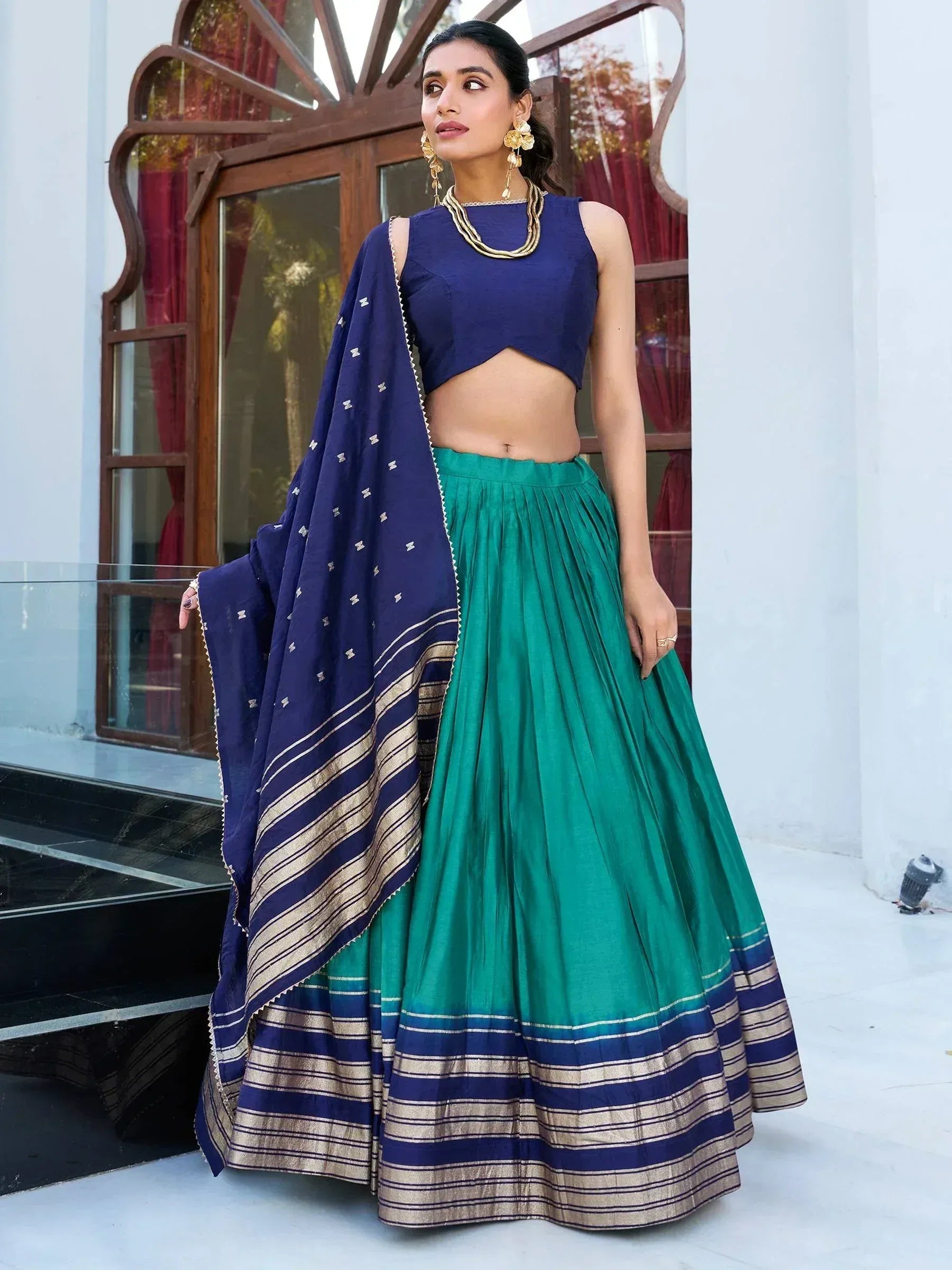Woman in blue and green lehenga choli with embroidered dupatta, ethnic Indian wear