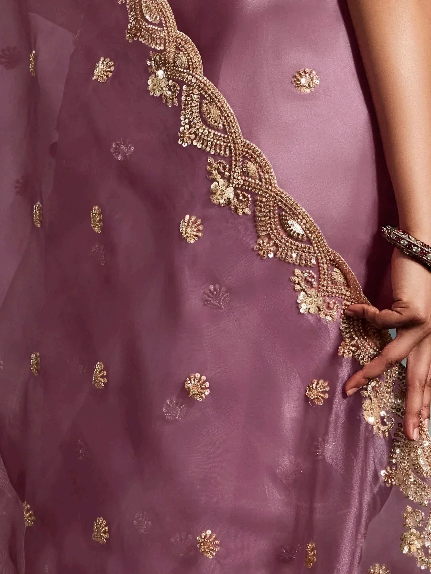 Purple ethnic gown with gold sequin embroidery and floral detailing, perfect for Indian weddings or festive occasions.