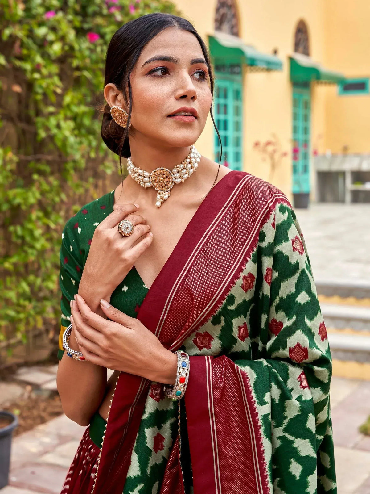 Woman in green and maroon ikat saree with pearl jewelry, traditional Indian ethnic wear