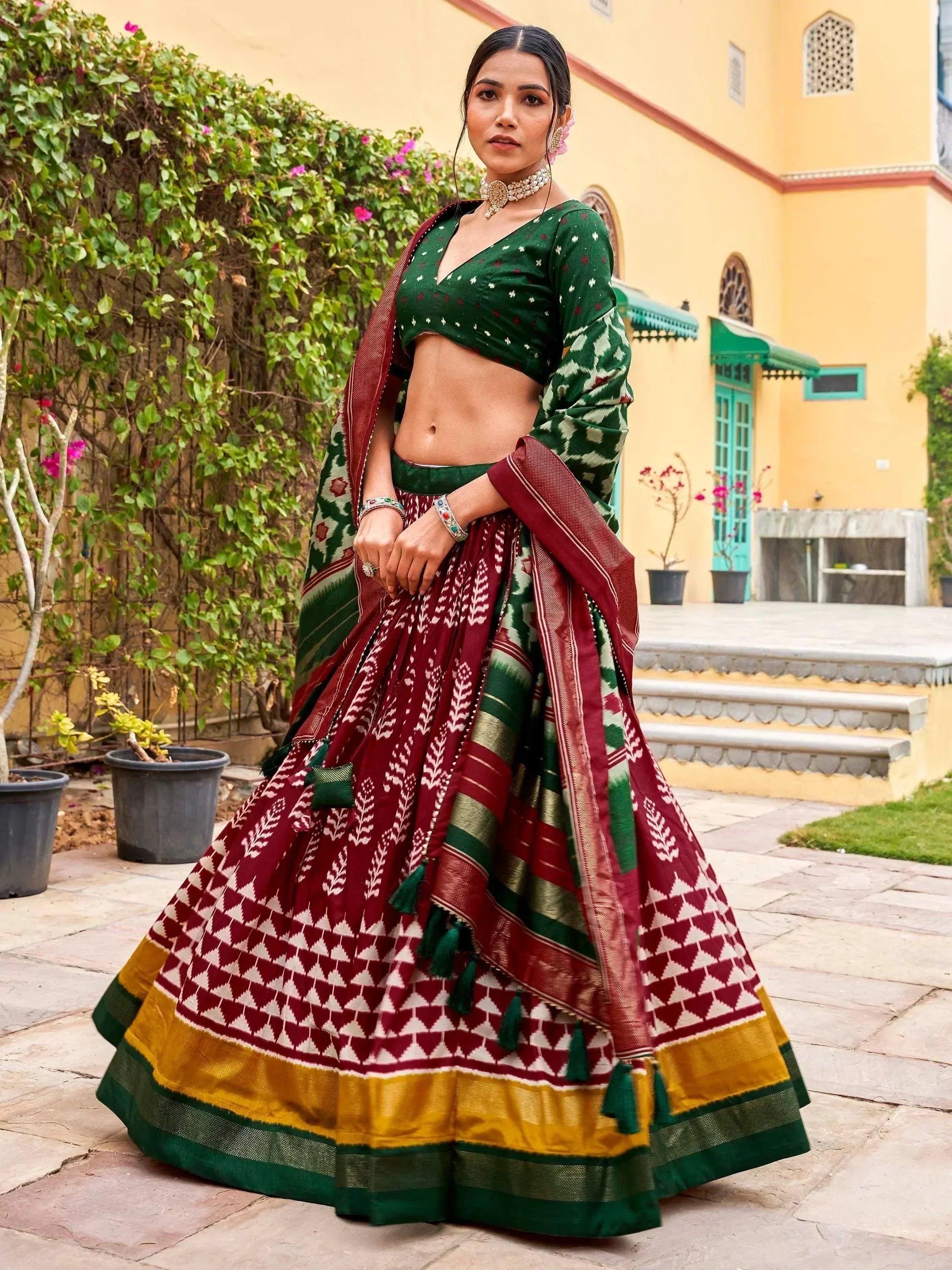 Green and maroon ethnic lehenga choli with ikat print, perfect for Indian weddings and festive occasions.