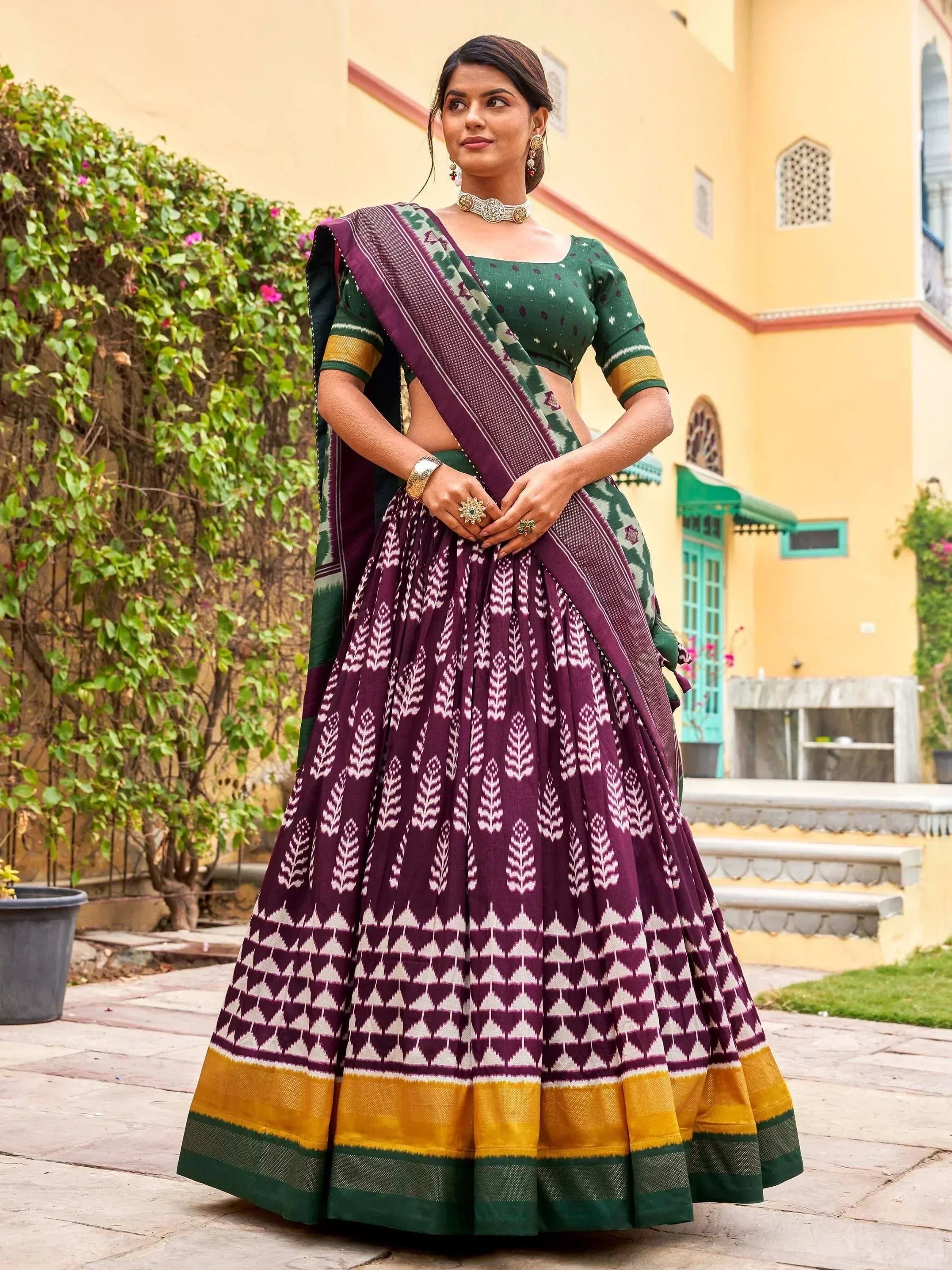Woman in purple and green Ikat lehenga choli with geometric print, traditional Indian ethnic wear