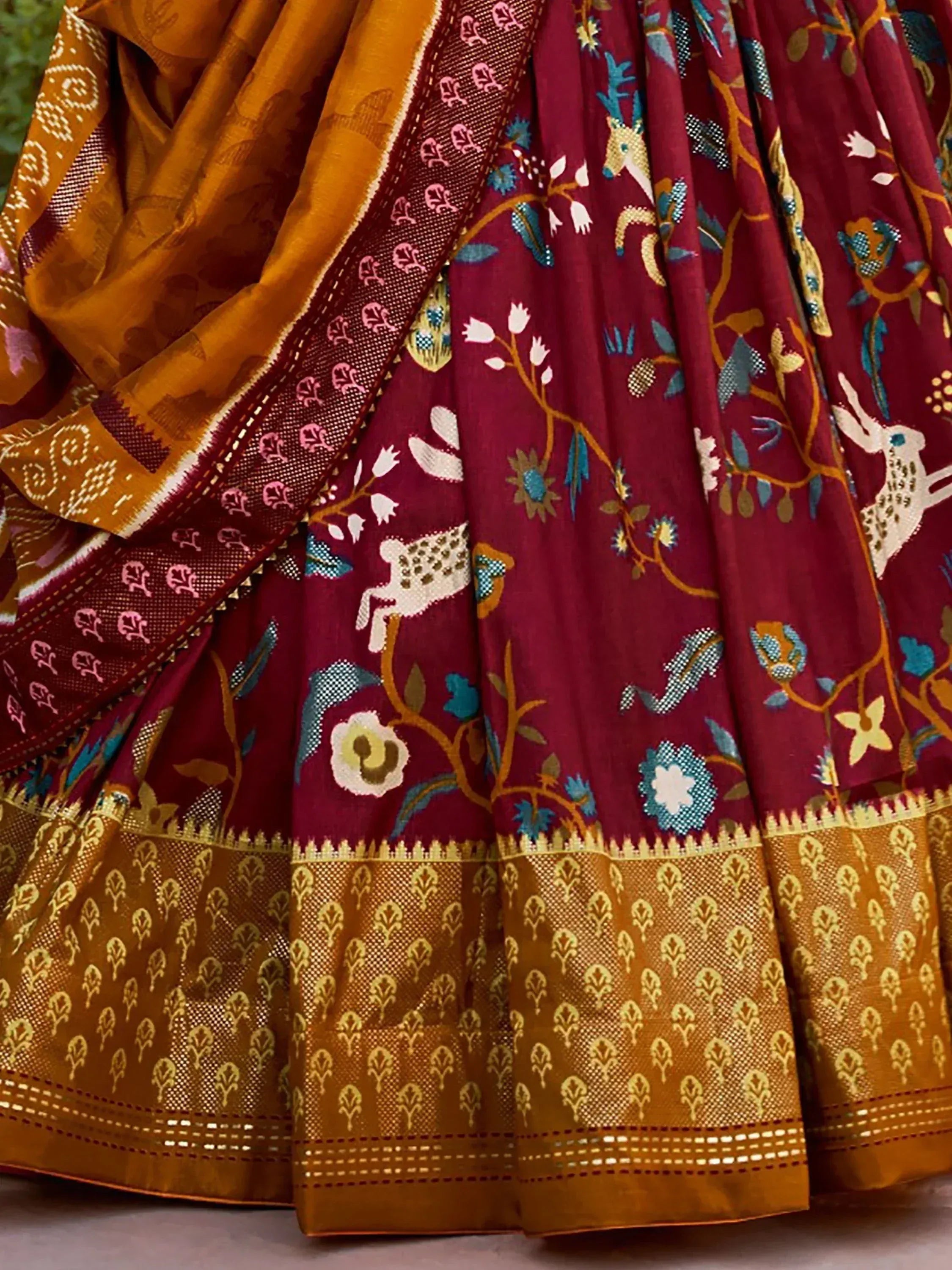 Maroon and mustard Indian saree with floral and animal motifs, perfect for ethnic wear occasions.