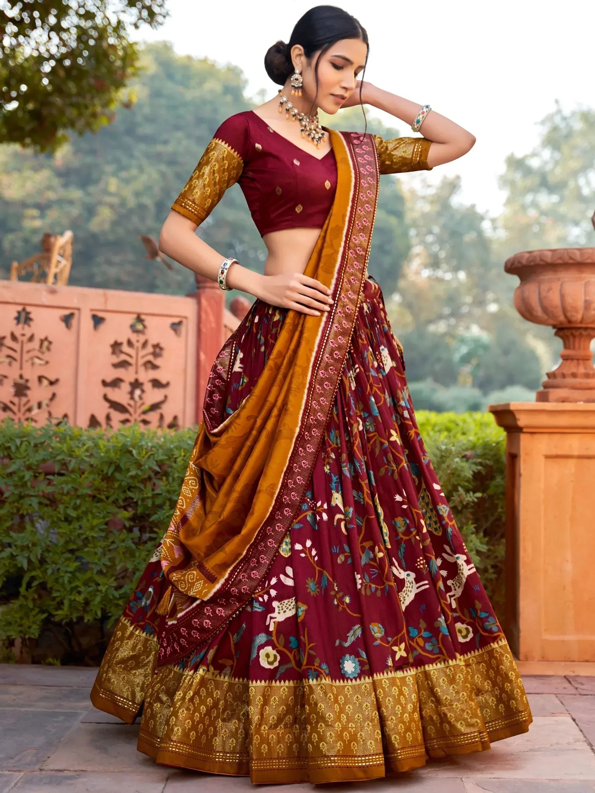 Maroon and gold designer lehenga choli with floral and animal motifs, perfect for Indian ethnic occasions.