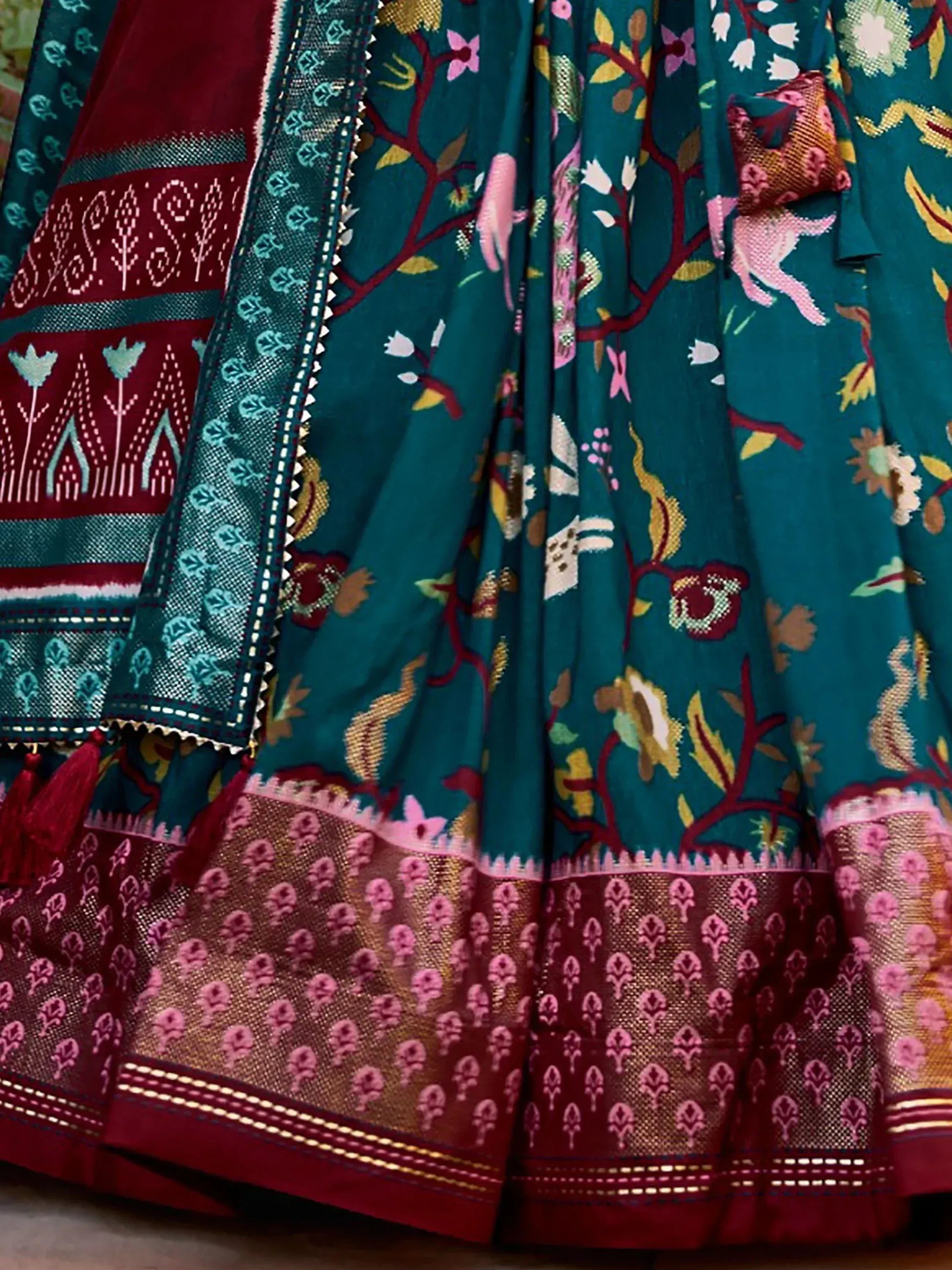 Teal and maroon ethnic lehenga with floral and animal print, intricate border detailing