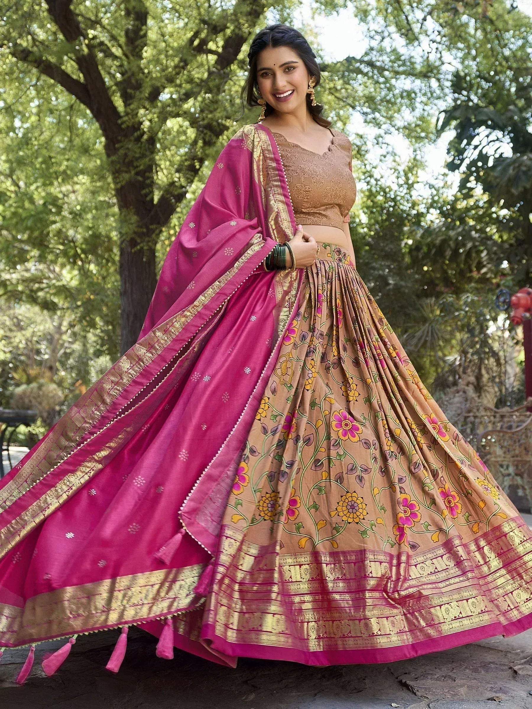 Woman in floral print lehenga choli with pink dupatta, ethnic Indian wear for festive occasions