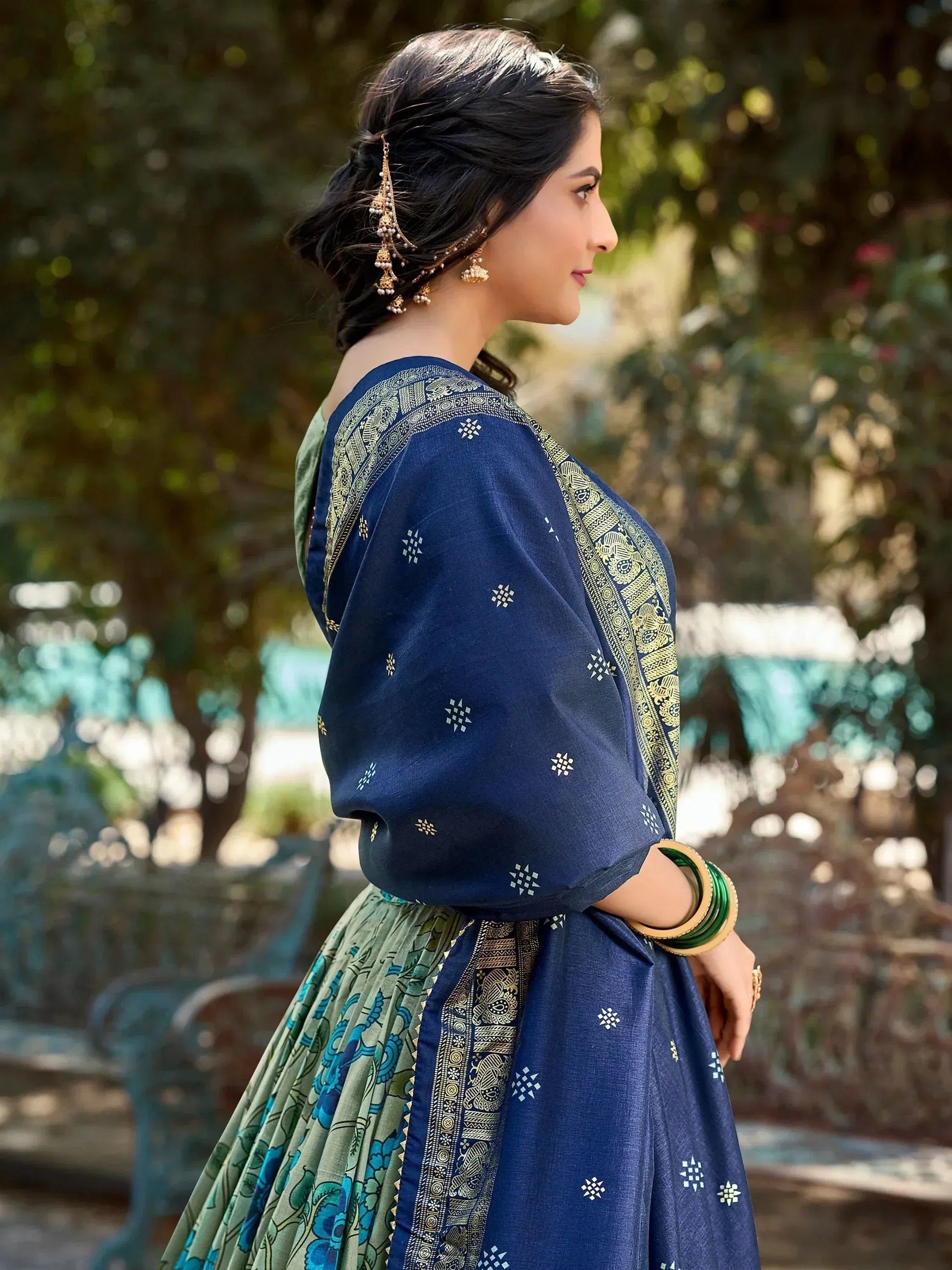 Woman in blue and green ethnic saree with gold embroidery, traditional Indian wear