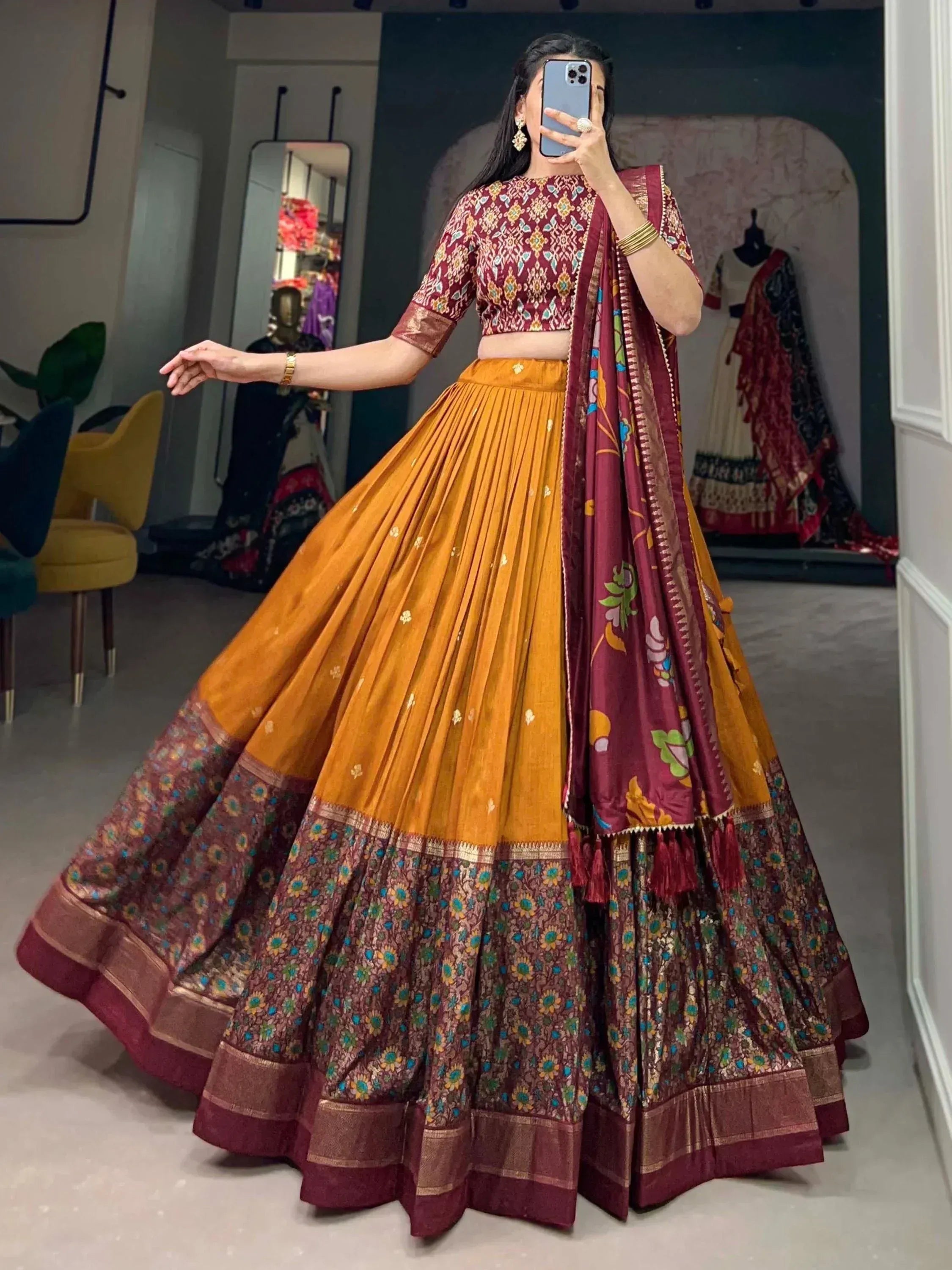 Woman in maroon and mustard Indian lehenga choli with floral dupatta, perfect for weddings and festivals