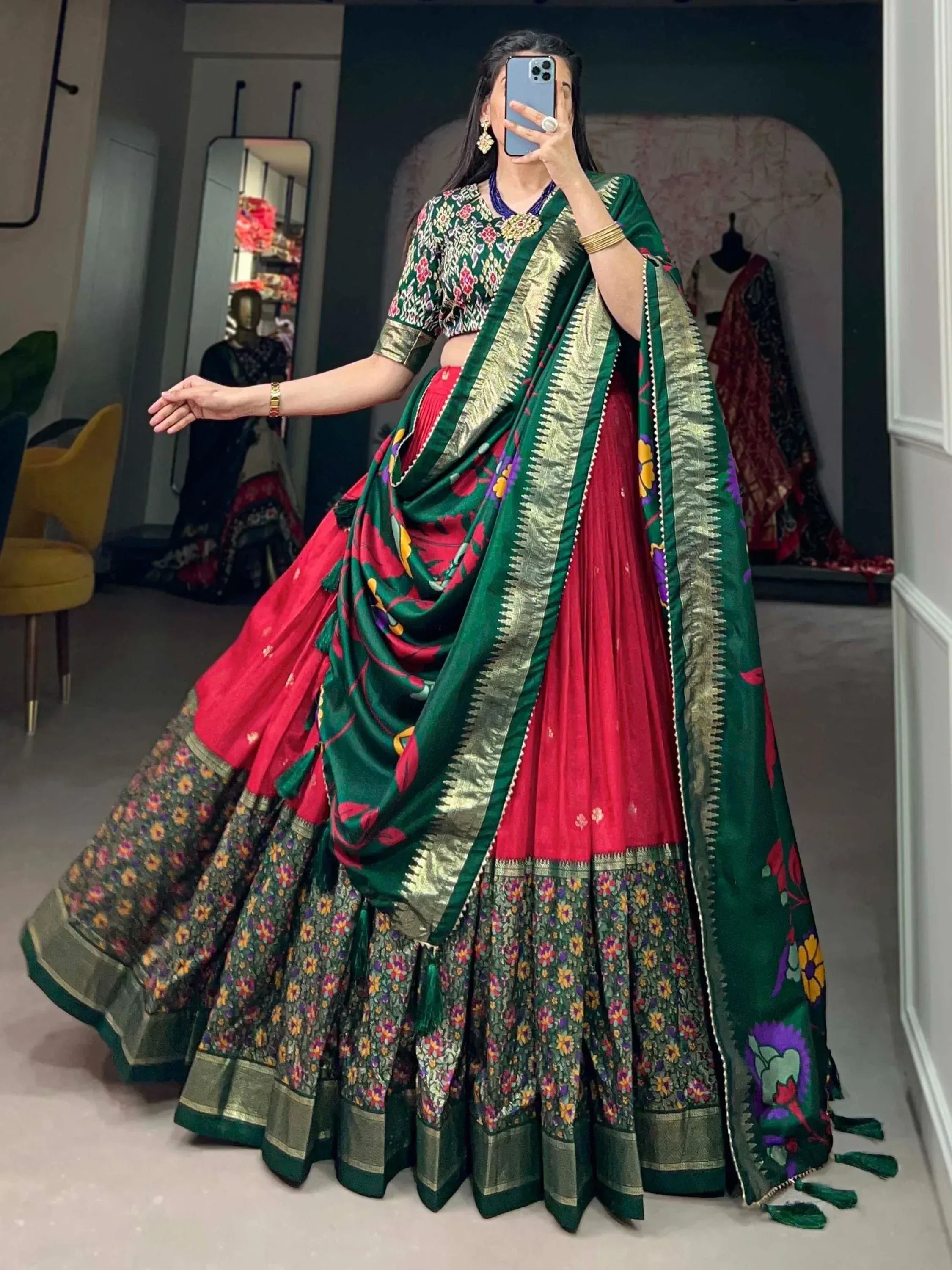 Woman in vibrant green and red floral lehenga choli with gold border, perfect for Indian ethnic wear occasions