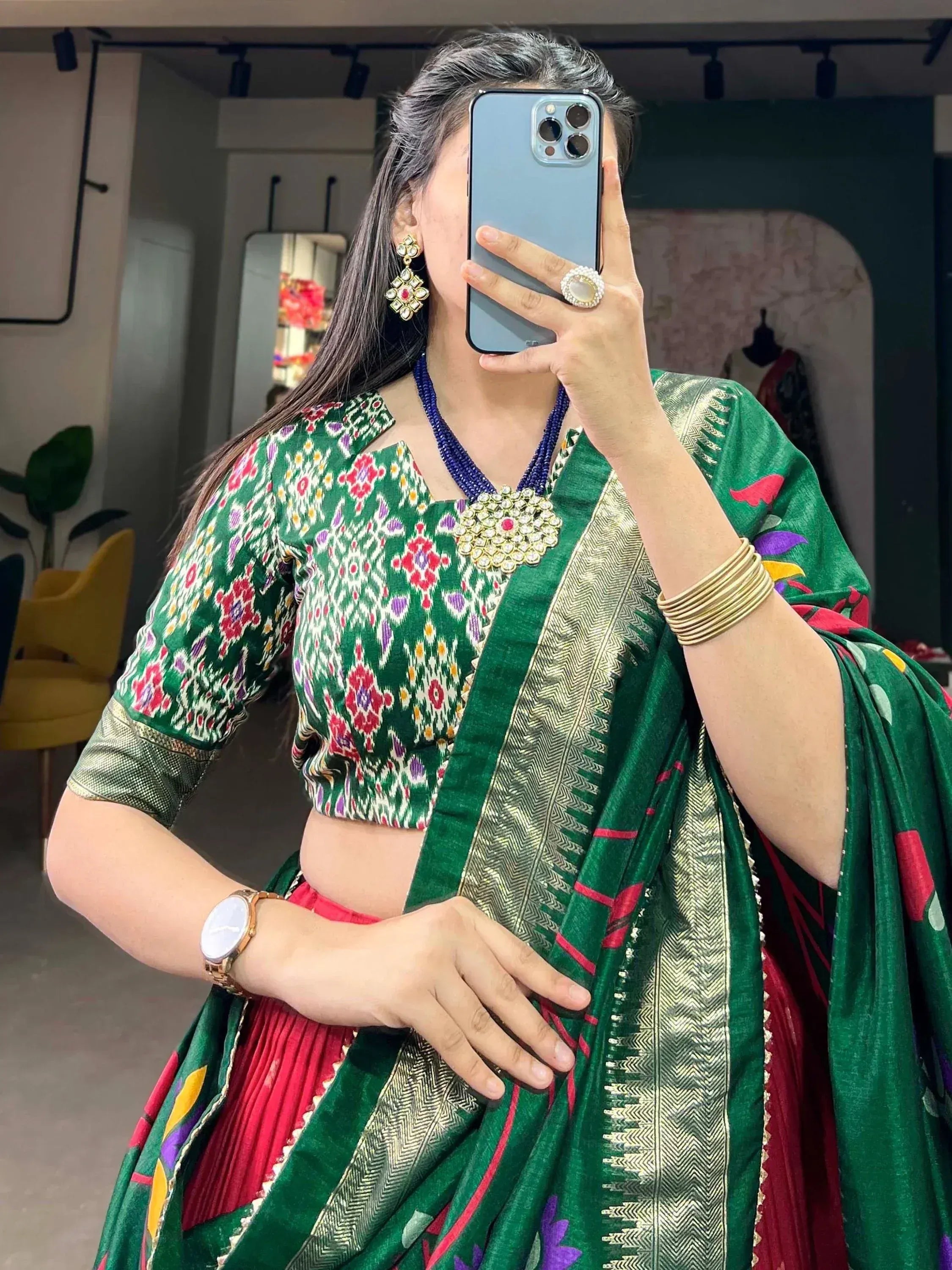 Green floral saree with gold border, paired with designer blouse and ethnic jewelry
