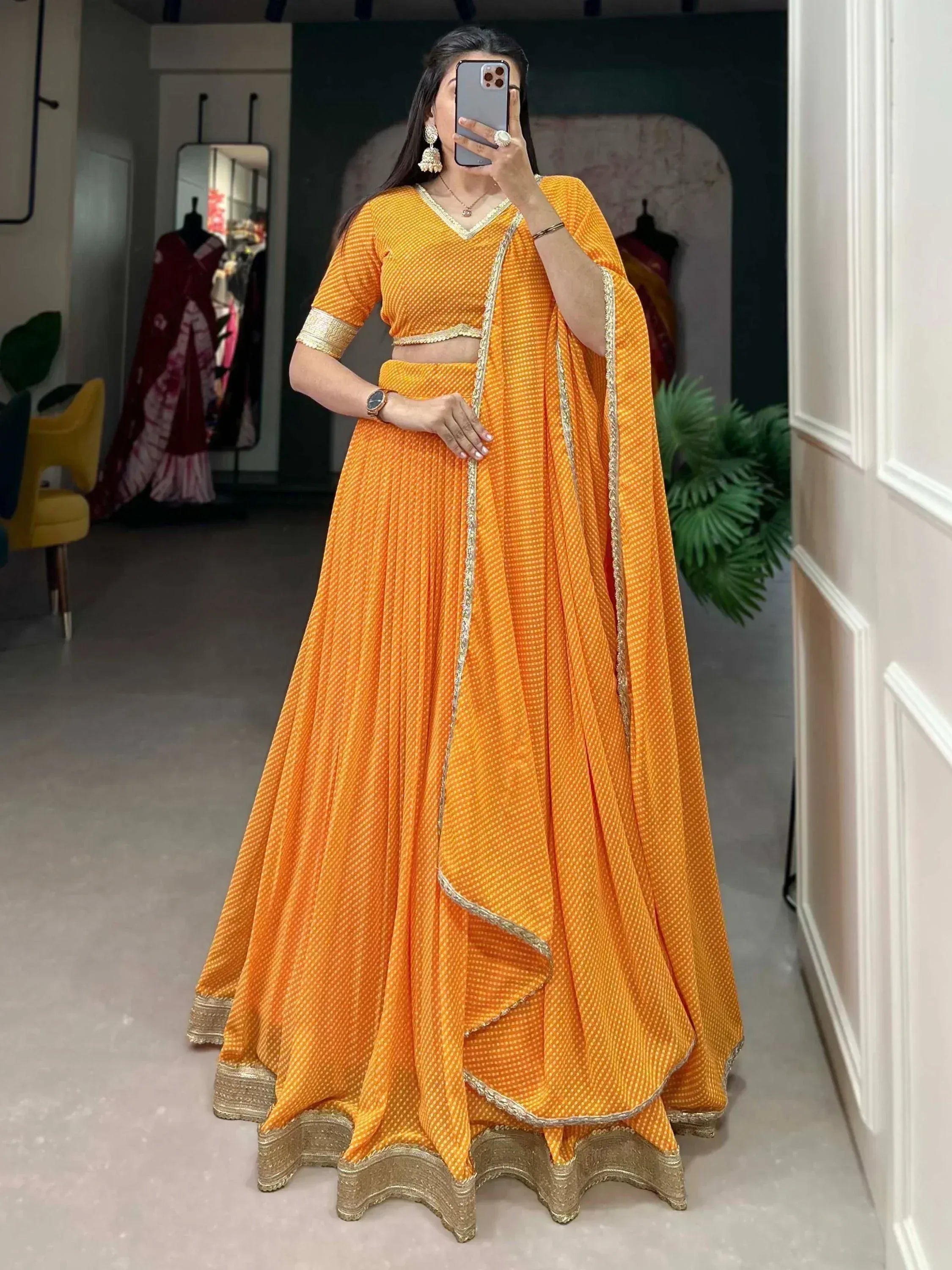 Vibrant orange ethnic lehenga choli with gold trim, perfect for Indian weddings and festive occasions.