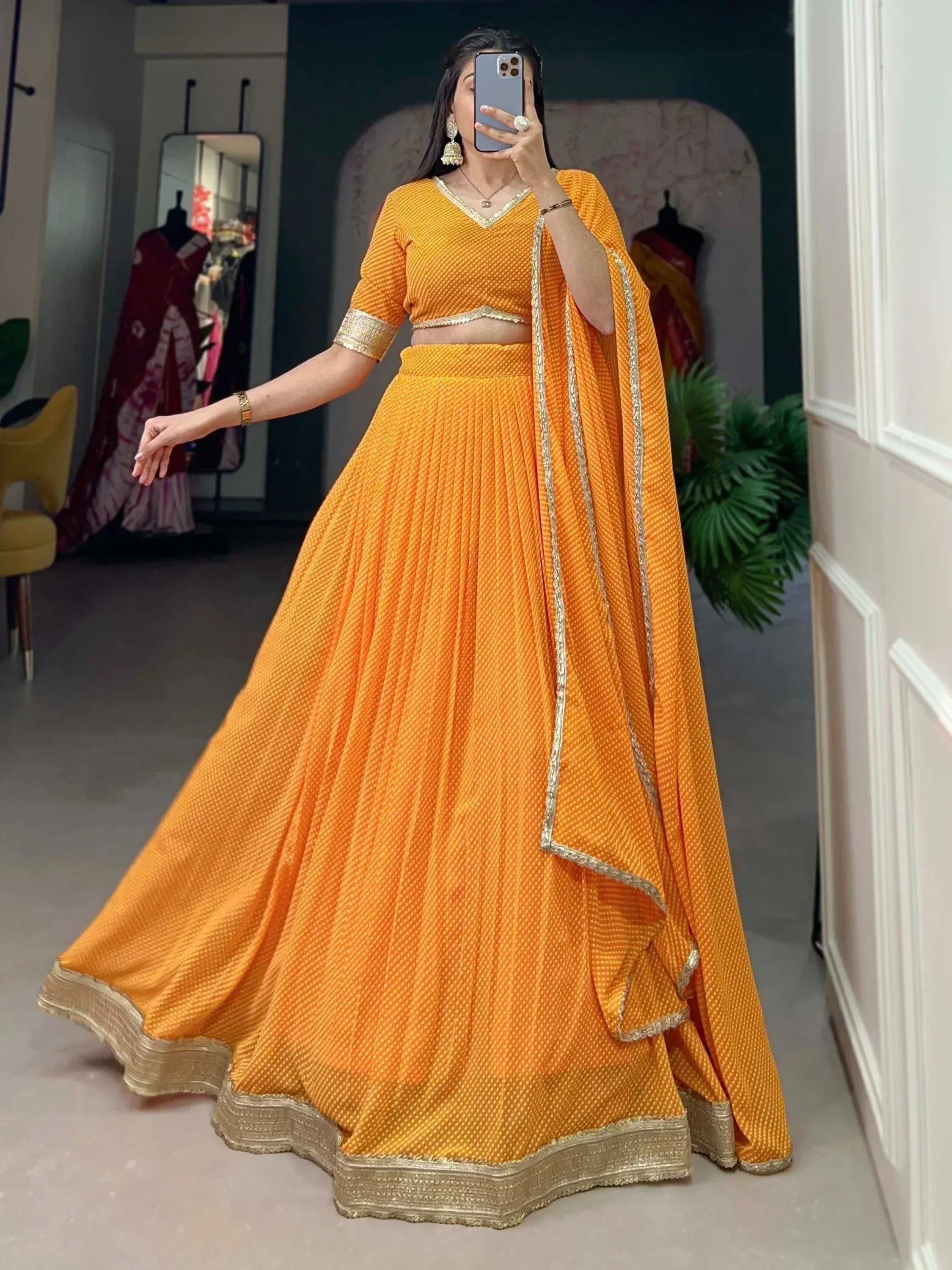 Vibrant orange lehenga choli with gold trim, perfect for Indian ethnic wear and festive occasions.