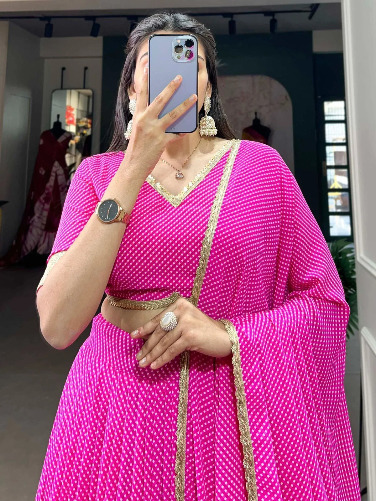 Pink checkered lehenga choli with gold embroidery, styled with jhumka earrings and statement ring