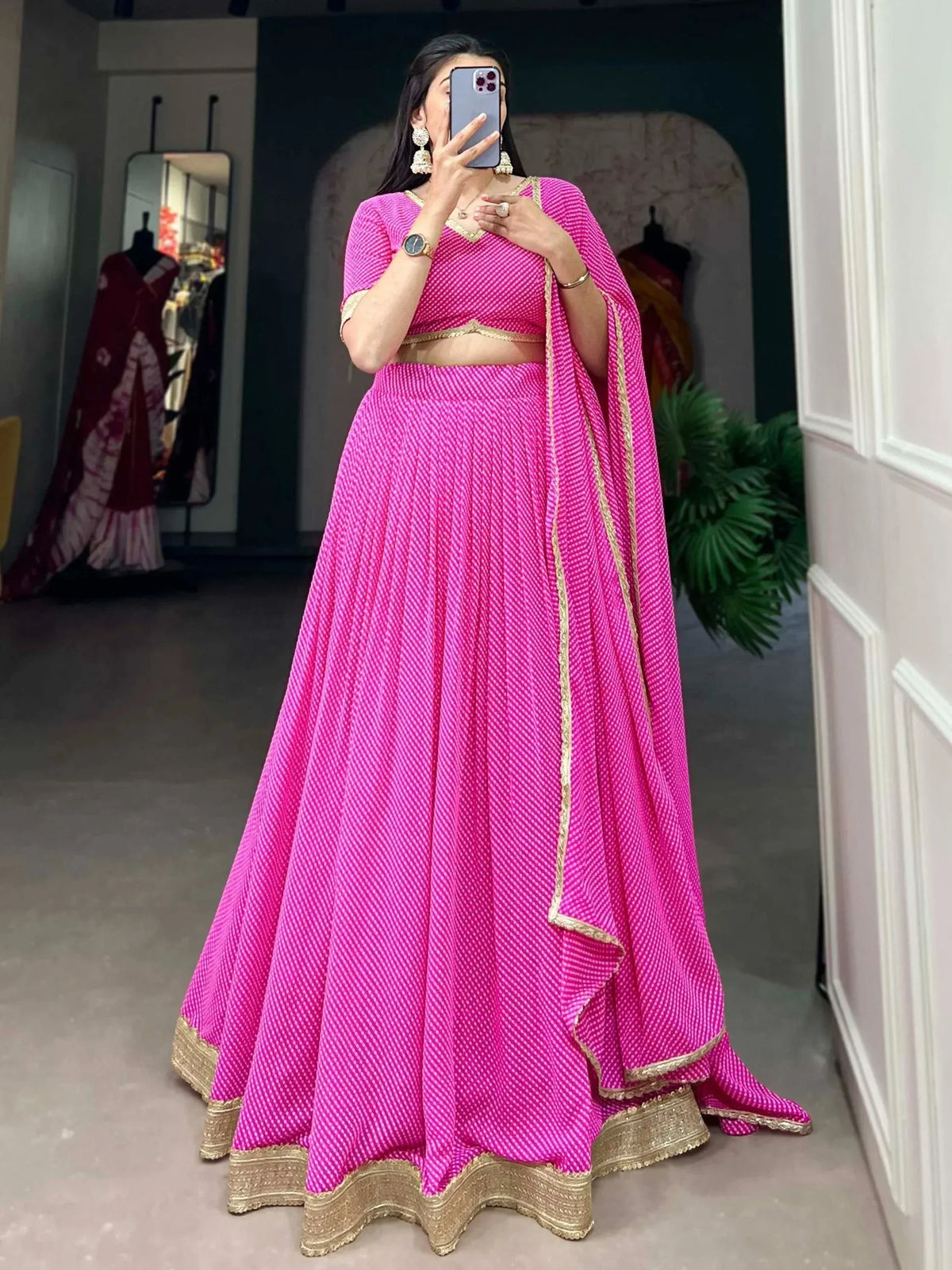 Bright pink lehenga choli with gold trim, perfect for Indian ethnic wear and festive occasions.
