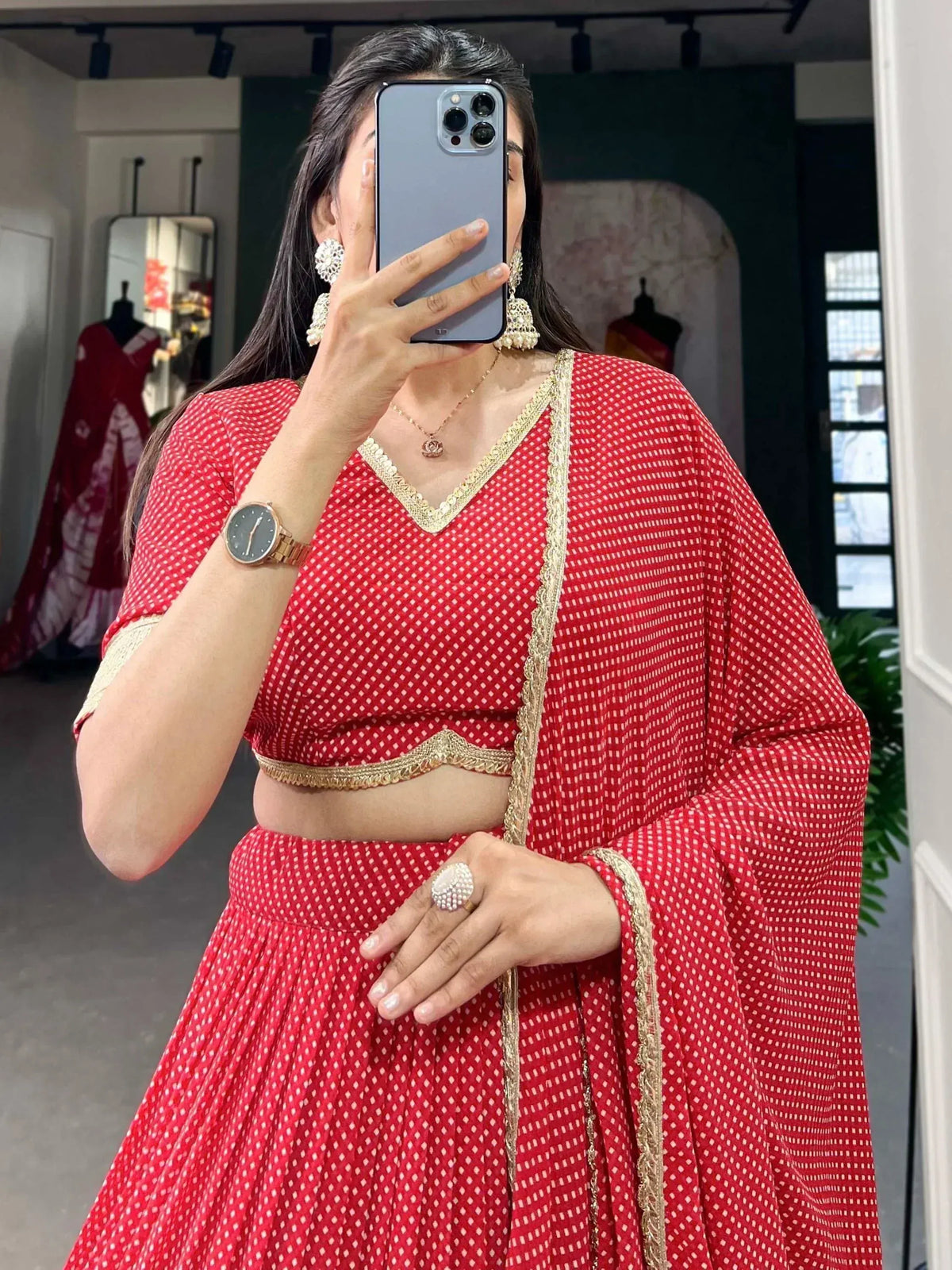 Red and white polka dot lehenga choli with gold trim, perfect for Indian ethnic wear occasions.