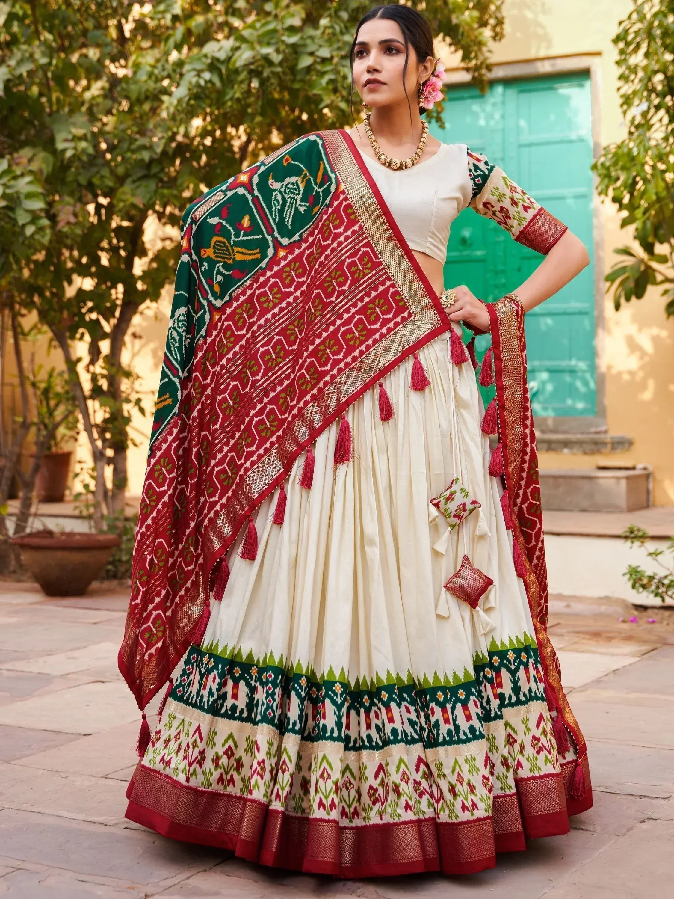 Cream lehenga choli with red green ikat print and tassels, perfect for Indian ethnic wear occasions