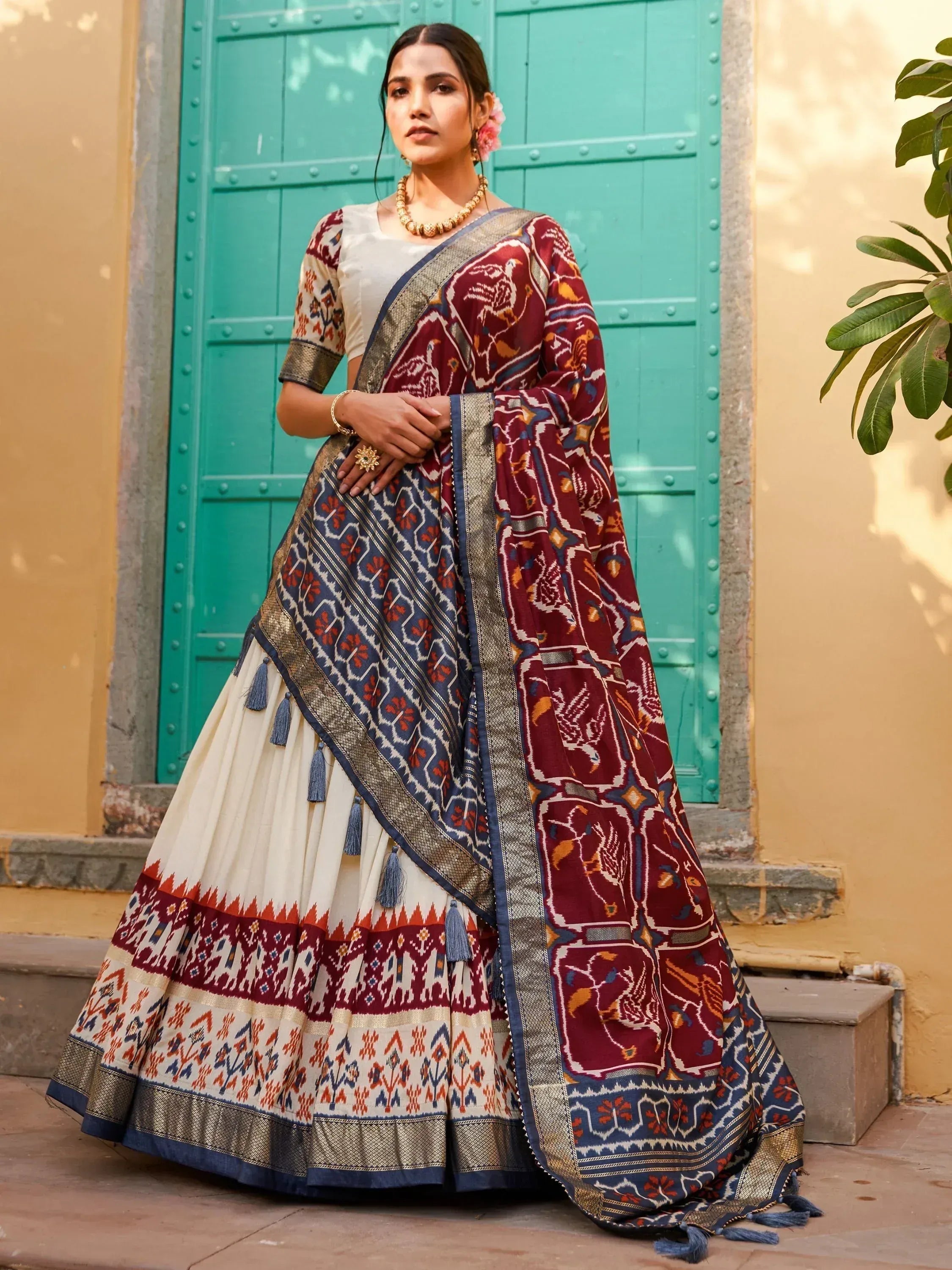 Woman in maroon and cream printed lehenga choli with ikat dupatta, ethnic Indian wear