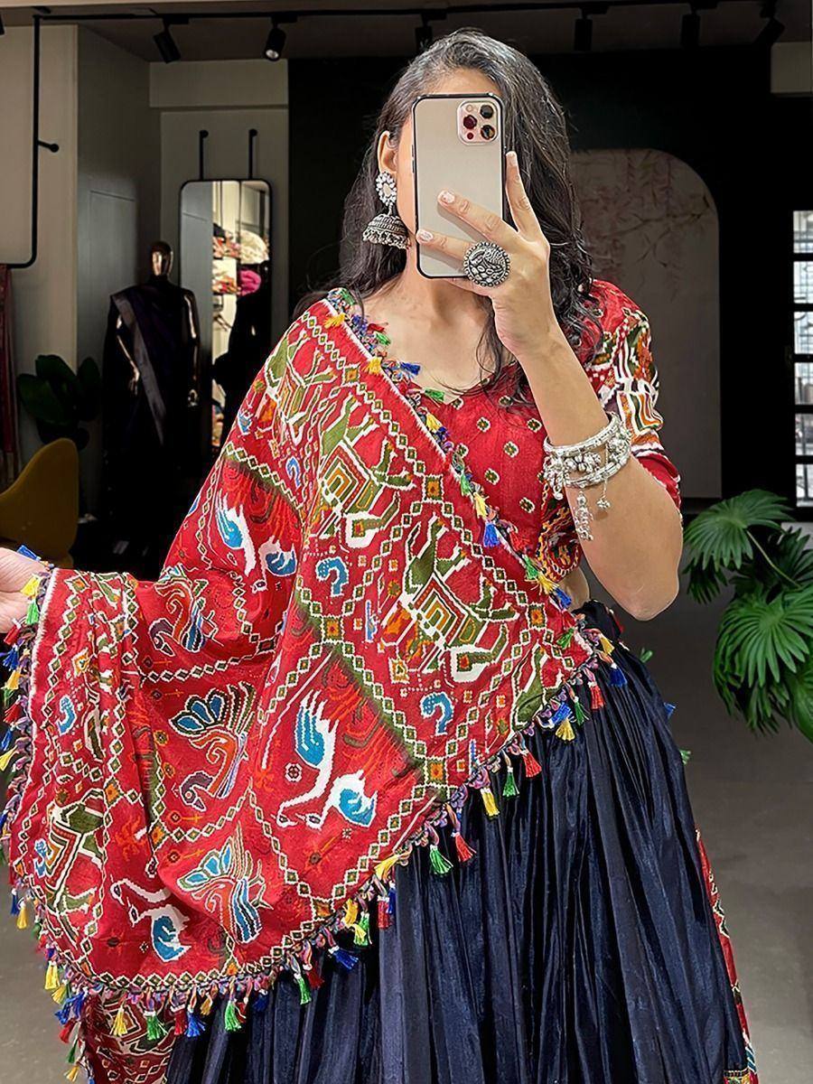 Red embroidered Indian ethnic top with tassels, paired with navy pleated skirt, styled with statement jewelry