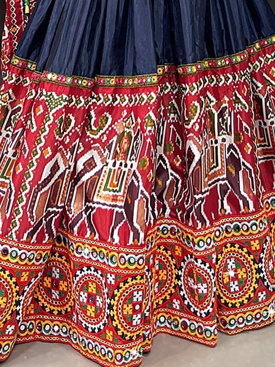 Vibrant red and navy blue ethnic lehenga with intricate mirror work and traditional Indian embroidery patterns